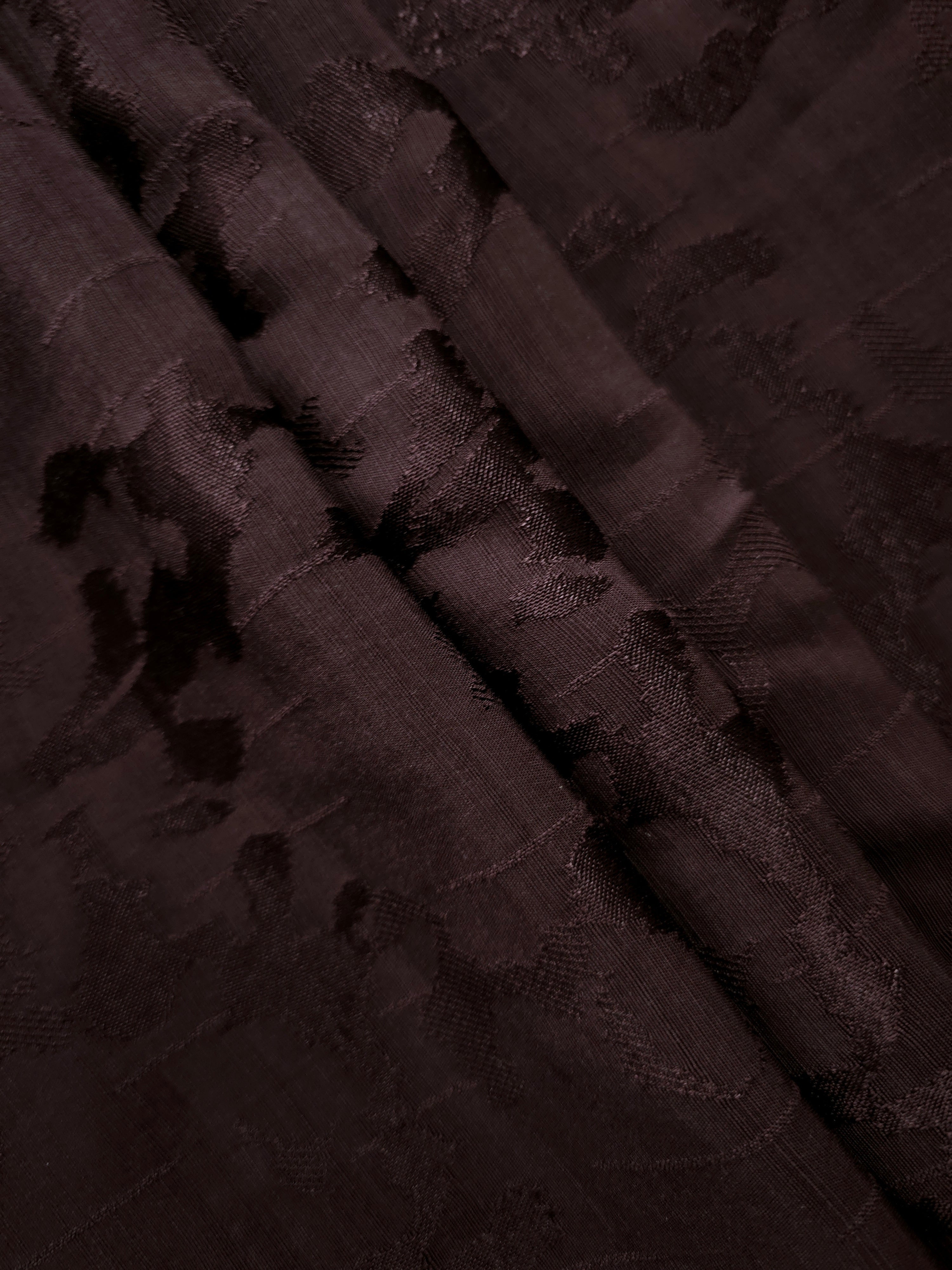 Stacked folds of wine burgundy abstract floral jacquard highlighting texture for kimono jackets, loose shirts and palazzo styles.