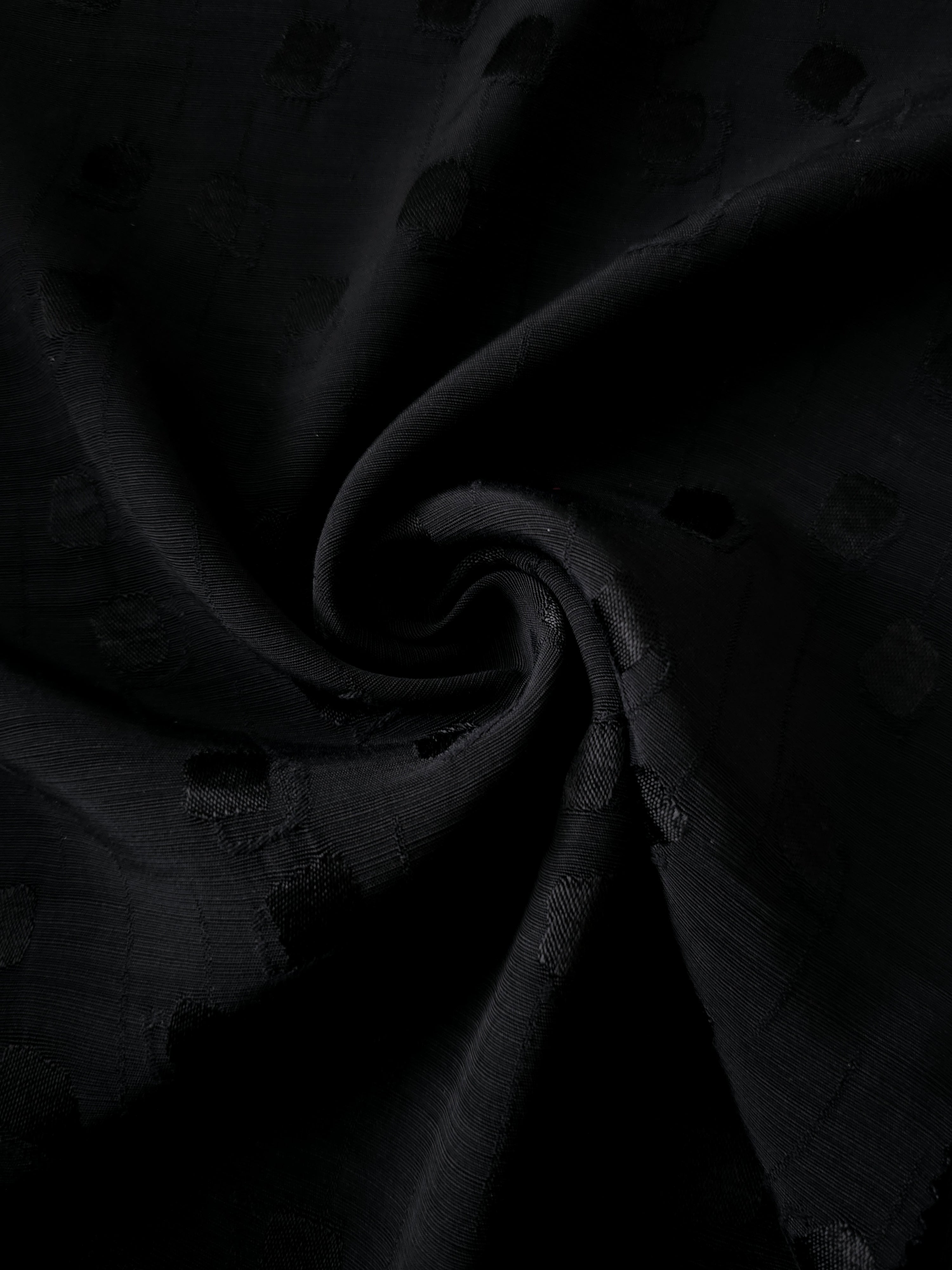 Spiral drape of jet black scattered square viscose rayon jacquard highlighting graceful movement for gowns, wrap skirts and kimono-style robes.