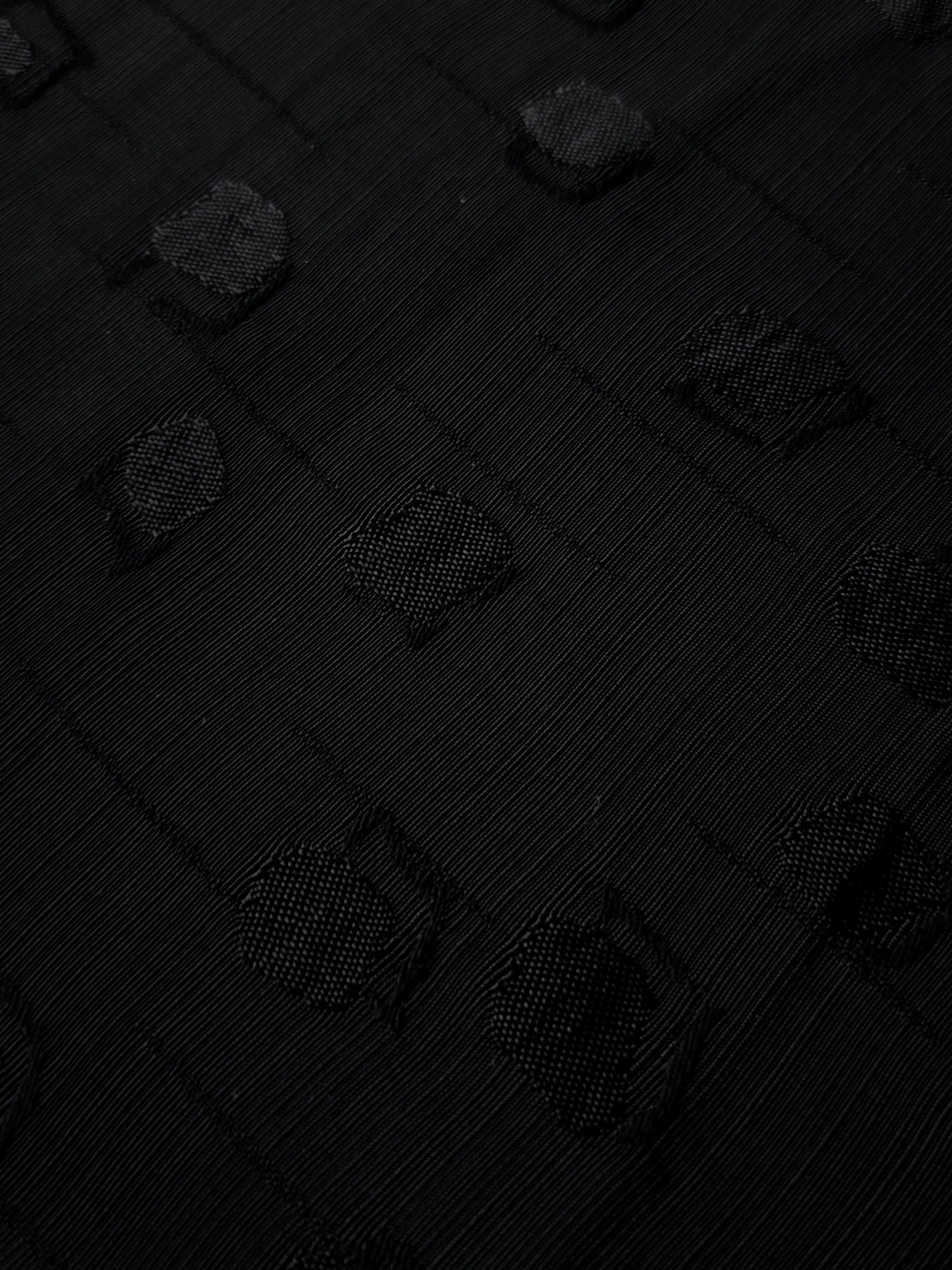 Close-up of jet black scattered square jacquard weave and tonal texture for refined blouses, formal tunics and detailed dressmaking.