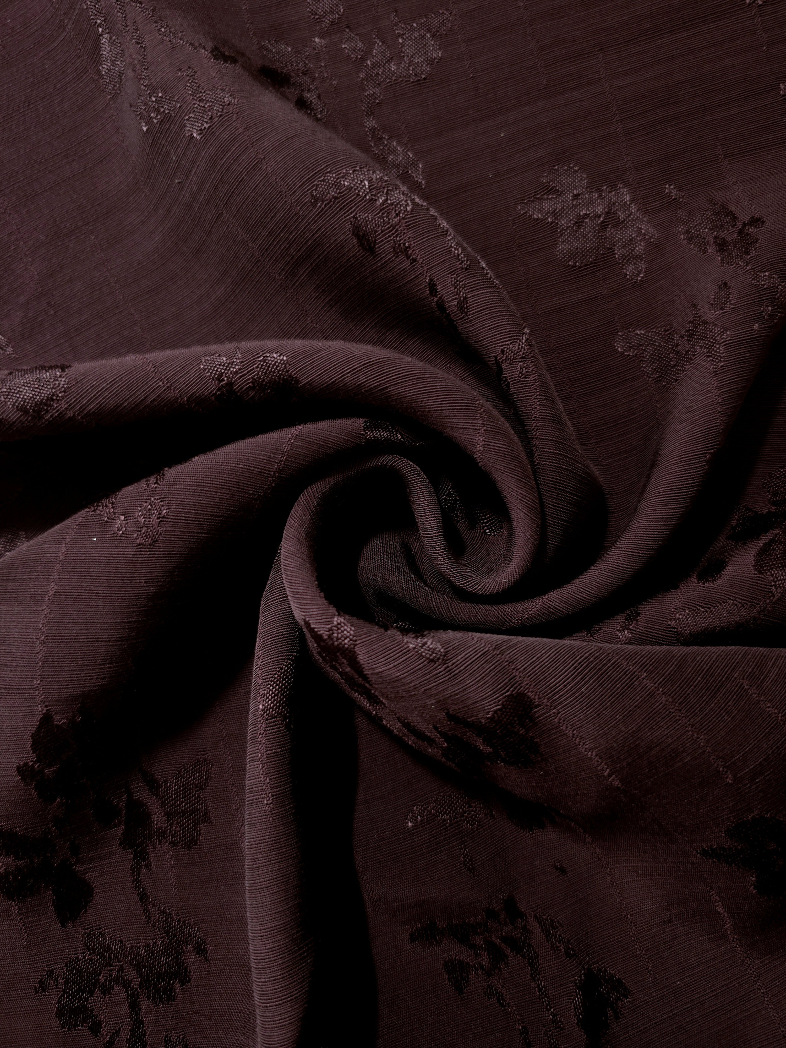 Deep burgundy floral jacquard arranged in gathered folds to show drape for voluminous sleeves, blouses and formal dresses.
