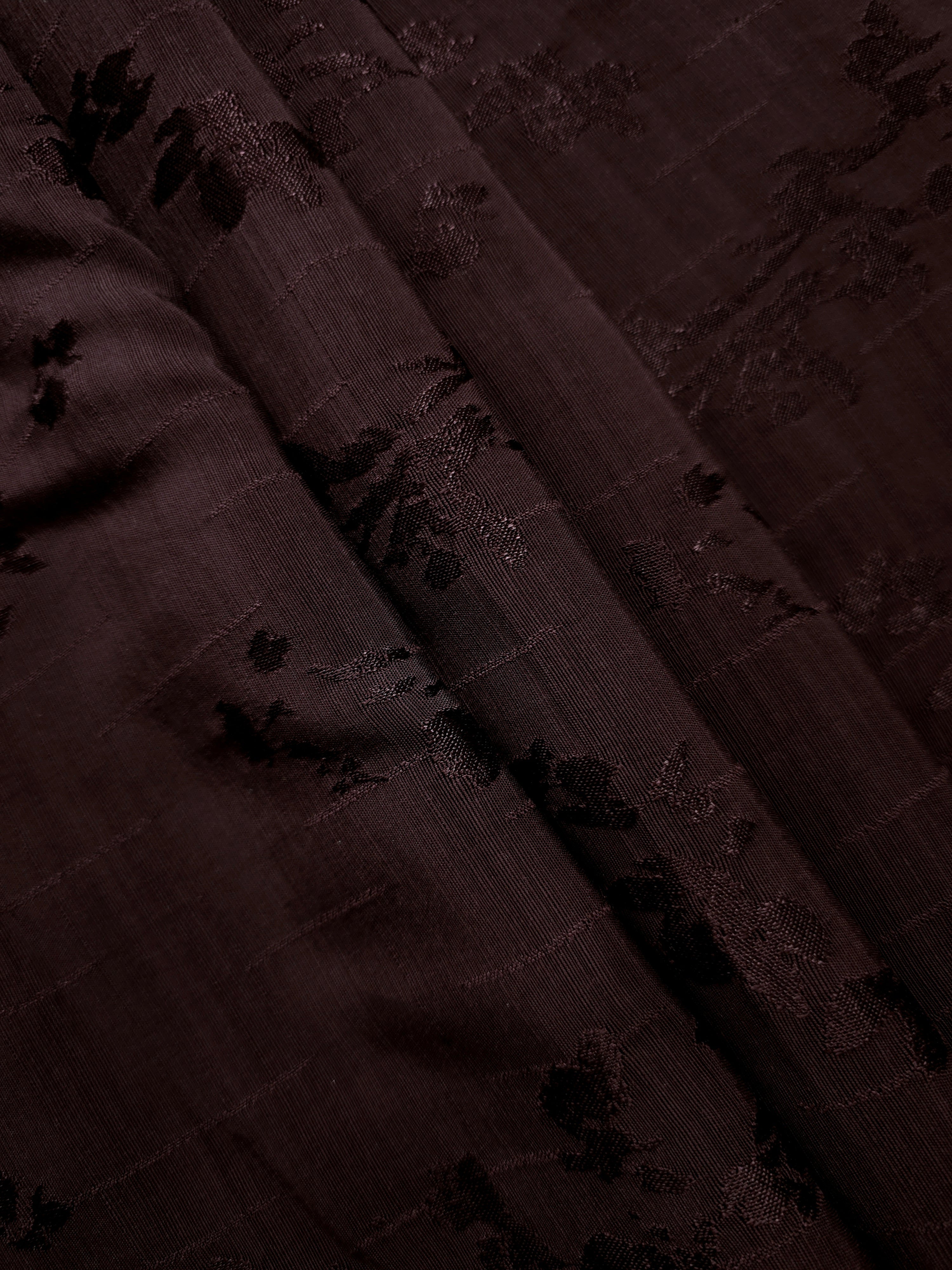 Folded layers of deep burgundy viscose rayon jacquard revealing subtle floral depth for abayas, kimono tops and wide-leg pants.