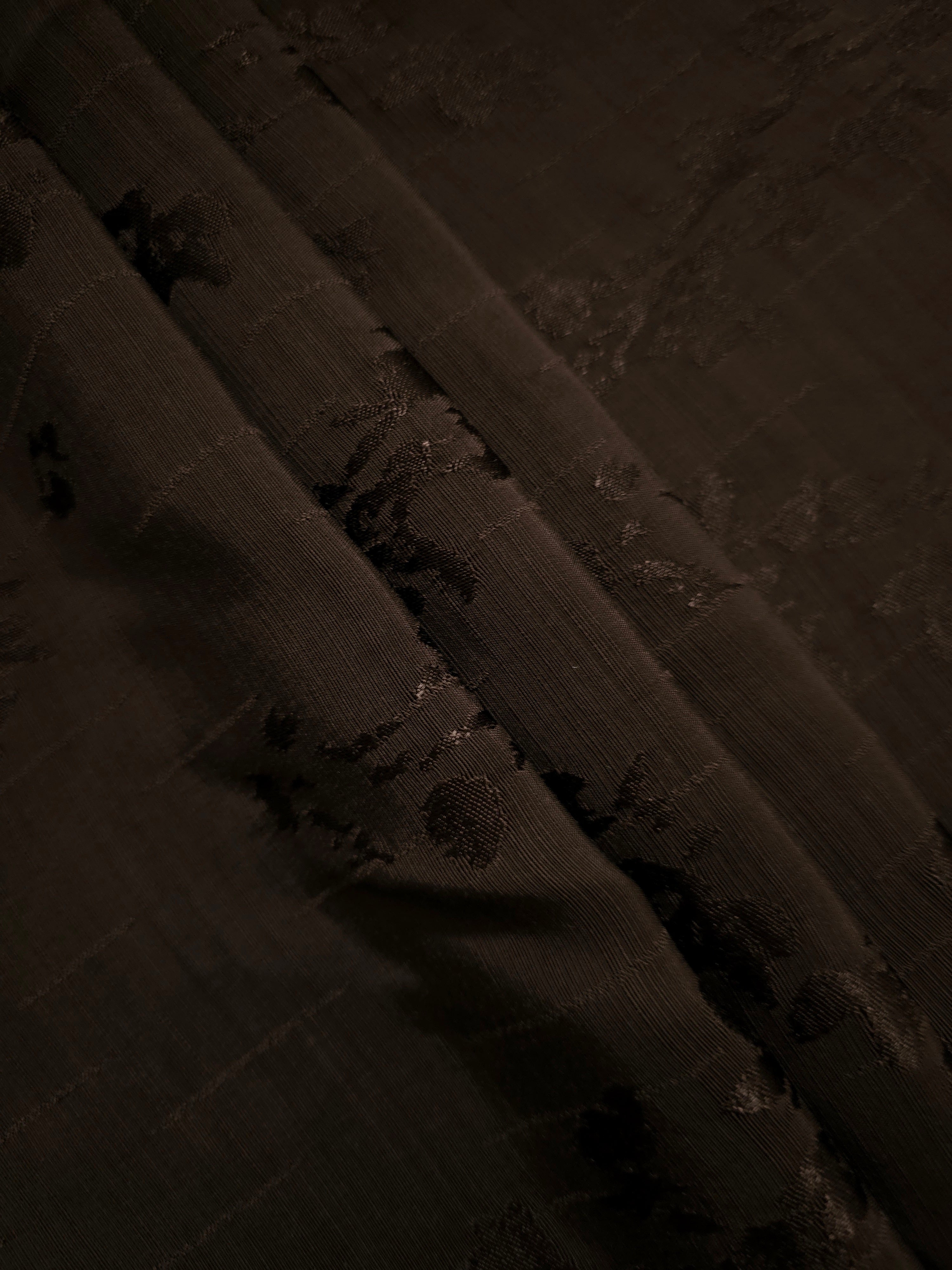Layered folds of espresso brown floral viscose jacquard demonstrating body and sheen for kimono jackets, abayas and palazzo trousers.