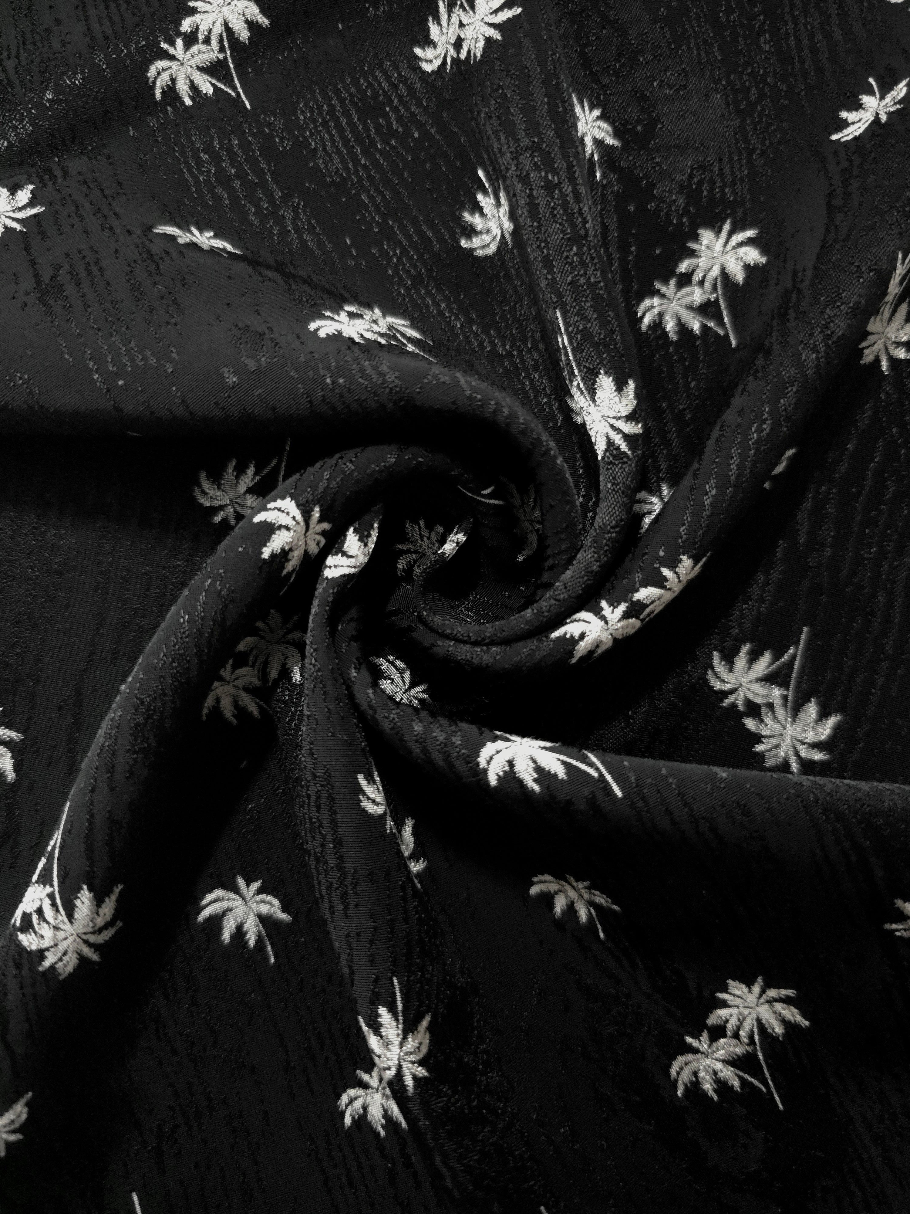 Gathered jet black rayon viscose jacquard showing flexible drape for wrap tops and wide flowing trousers.