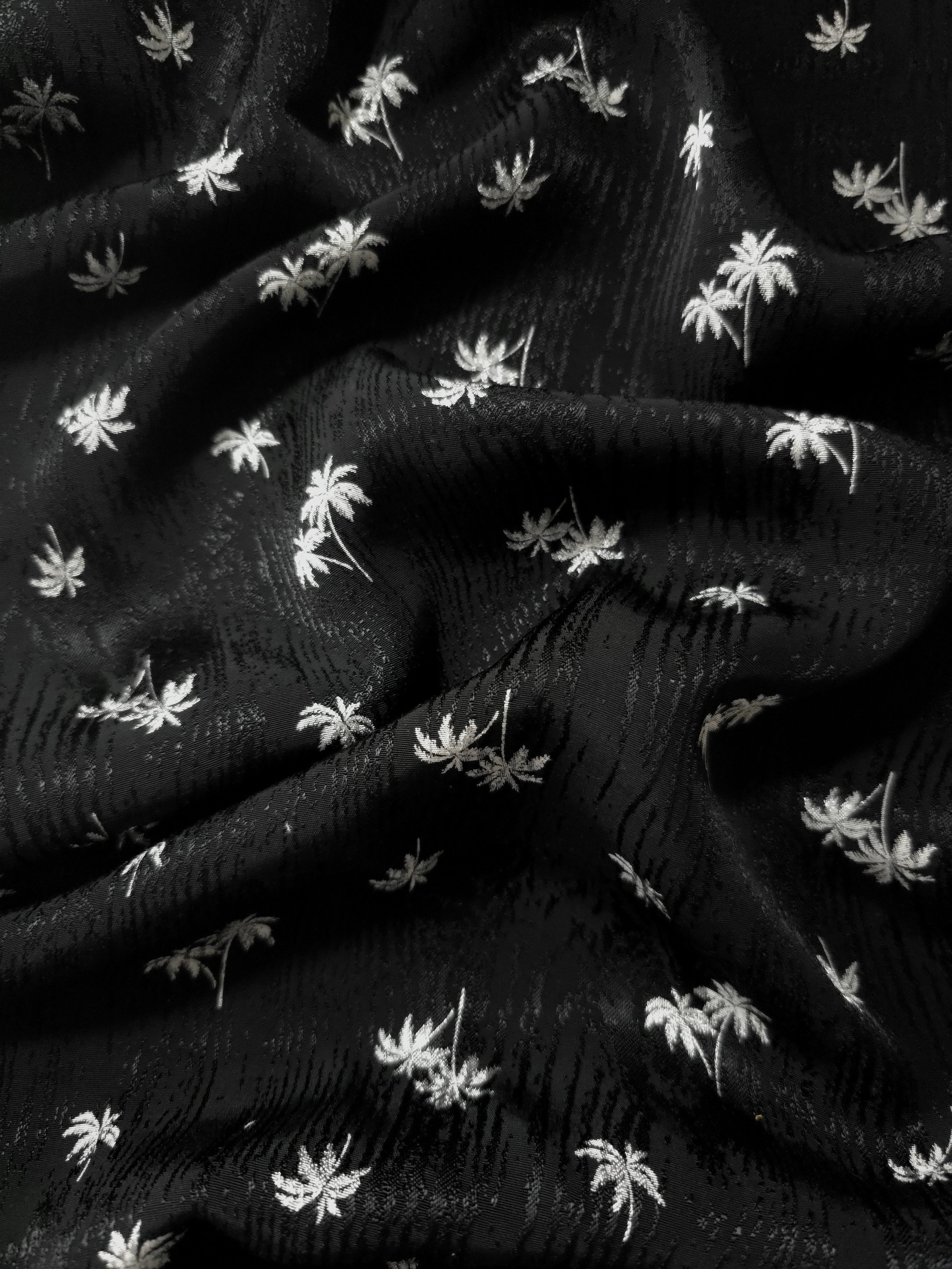 Jet black palm print rayon viscose jacquard in a fluid drape for evening dresses, abayas and longline layers.
