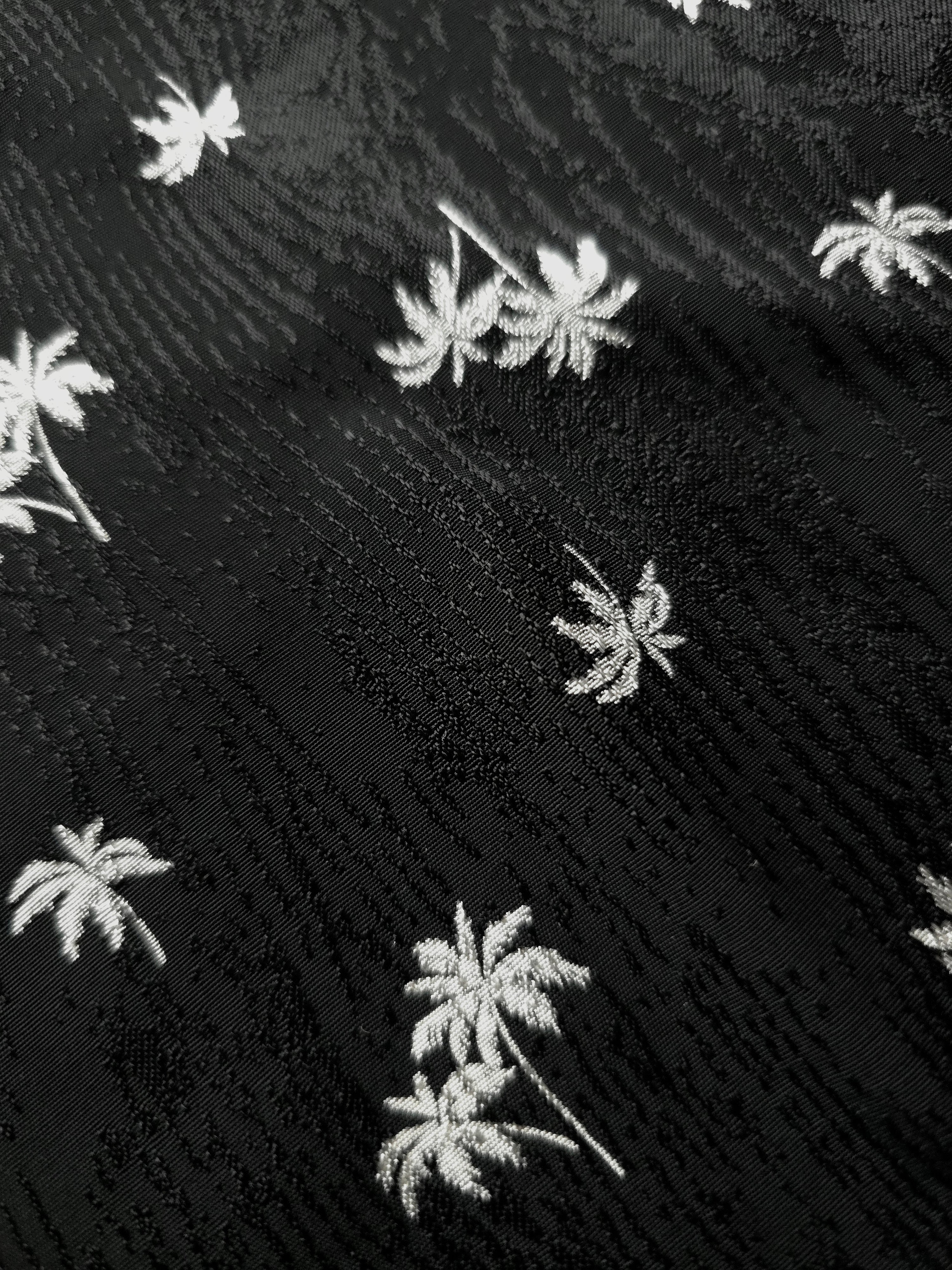 Macro view of jet black mini palm jacquard showing the raised weave for dress bodices and feature panels.