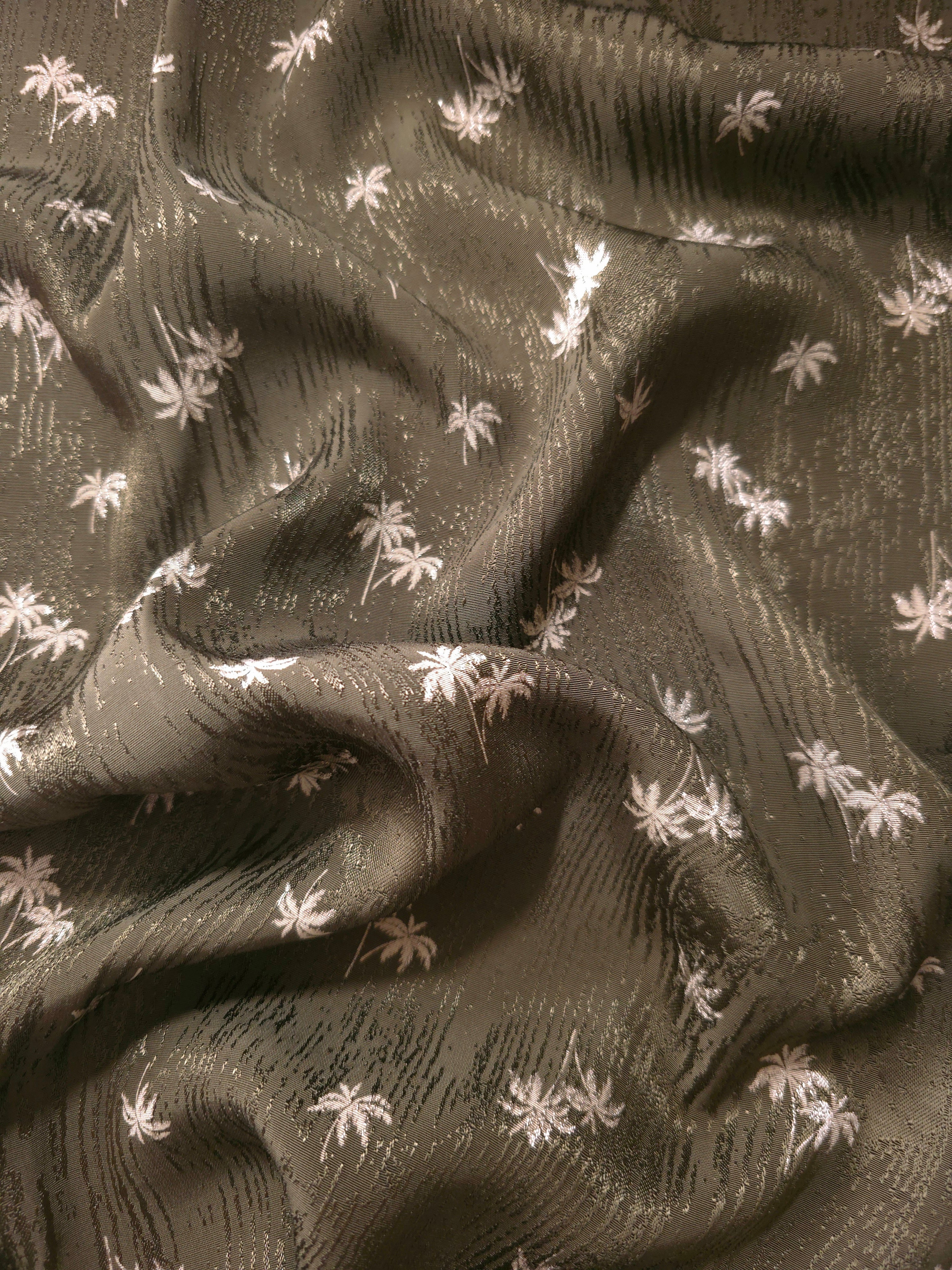 Soft drape of olive green mini palm tree rayon viscose jacquard, ideal for flowing dresses and long skirts.