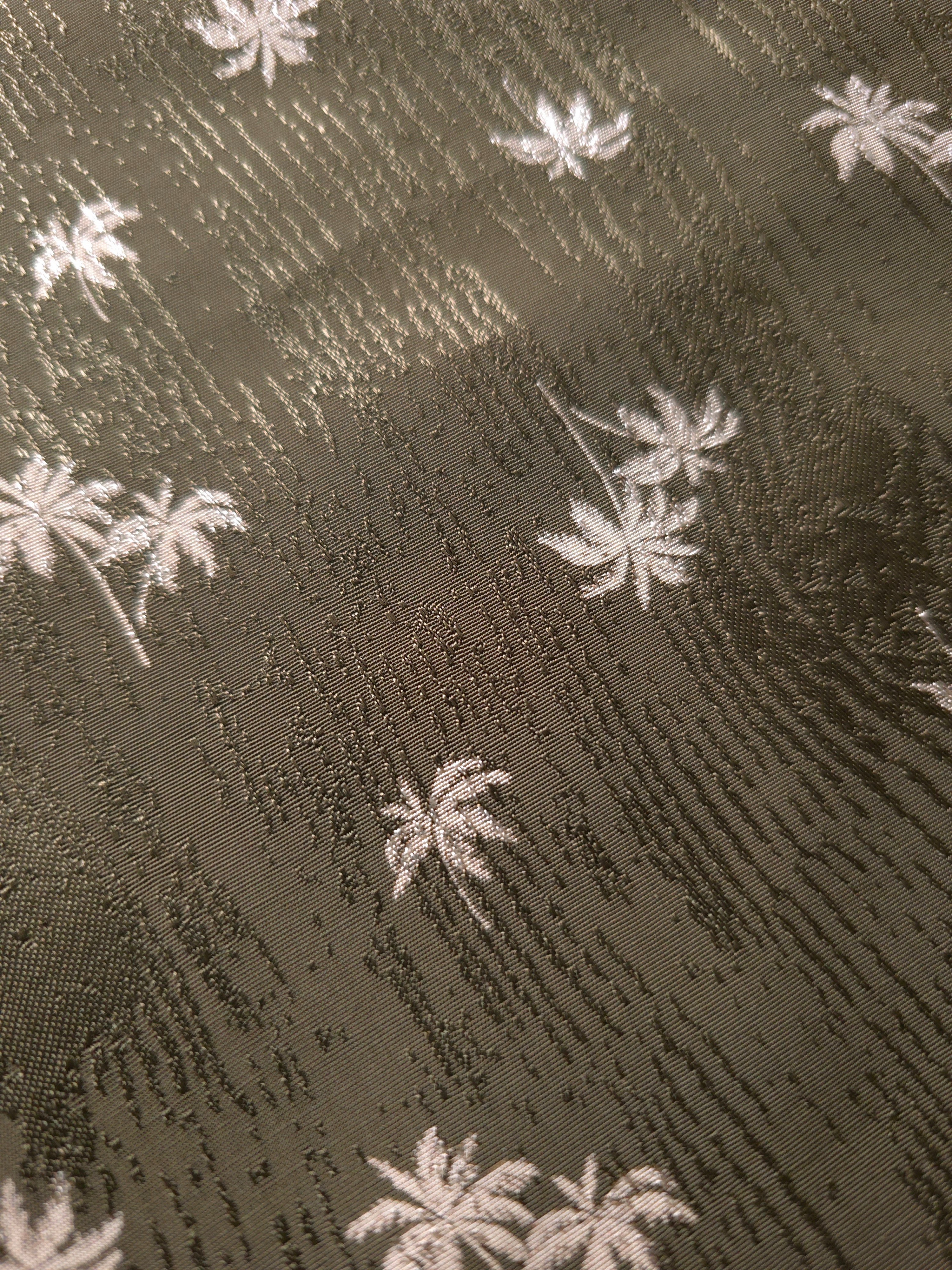 Close-up of olive green mini palm tree jacquard texture for tailored shirts, statement sleeves and dress panels.