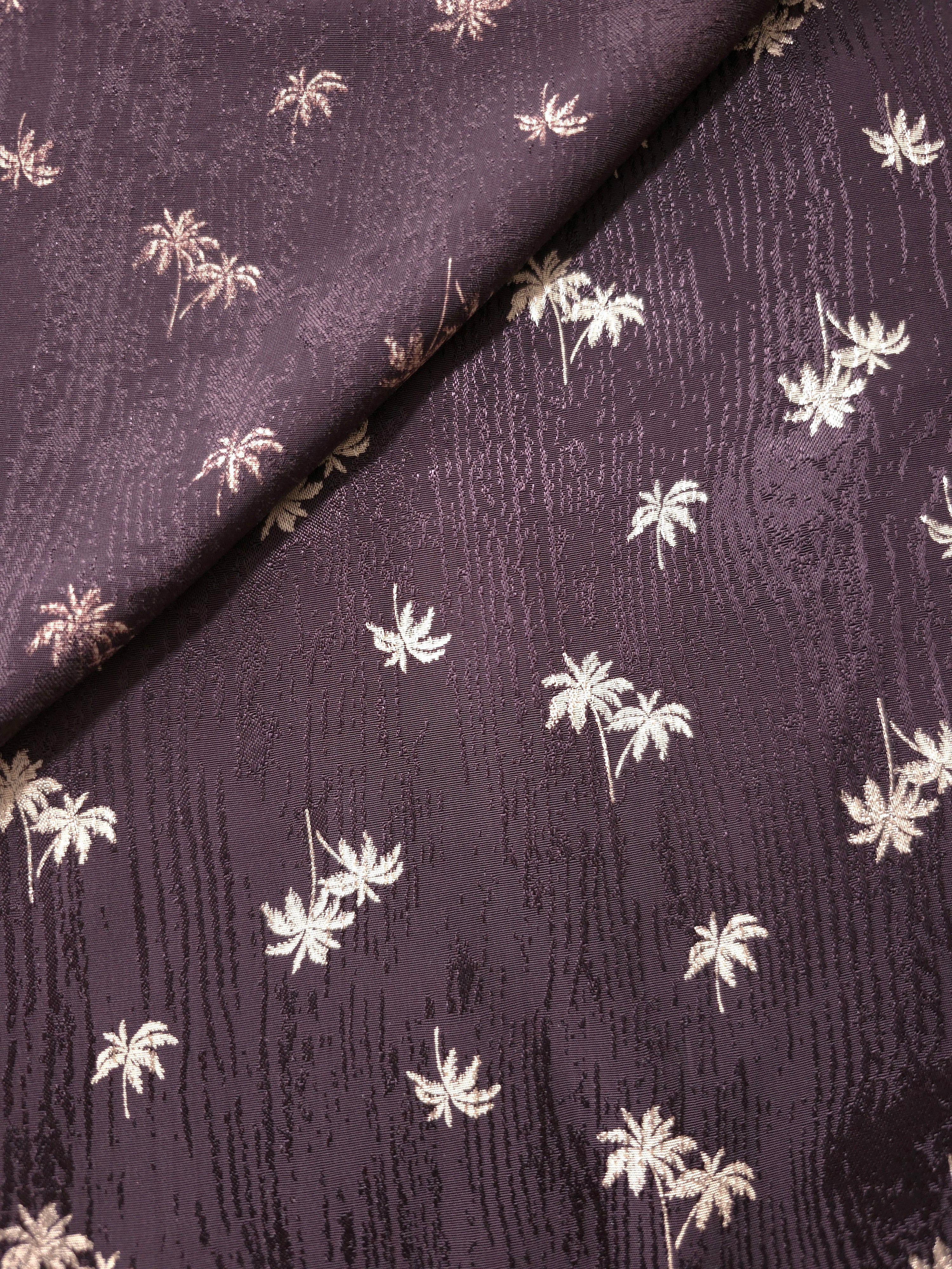Two-sided view of plum purple rayon viscose jacquard showing its face and reverse for kaftans and lined garments.