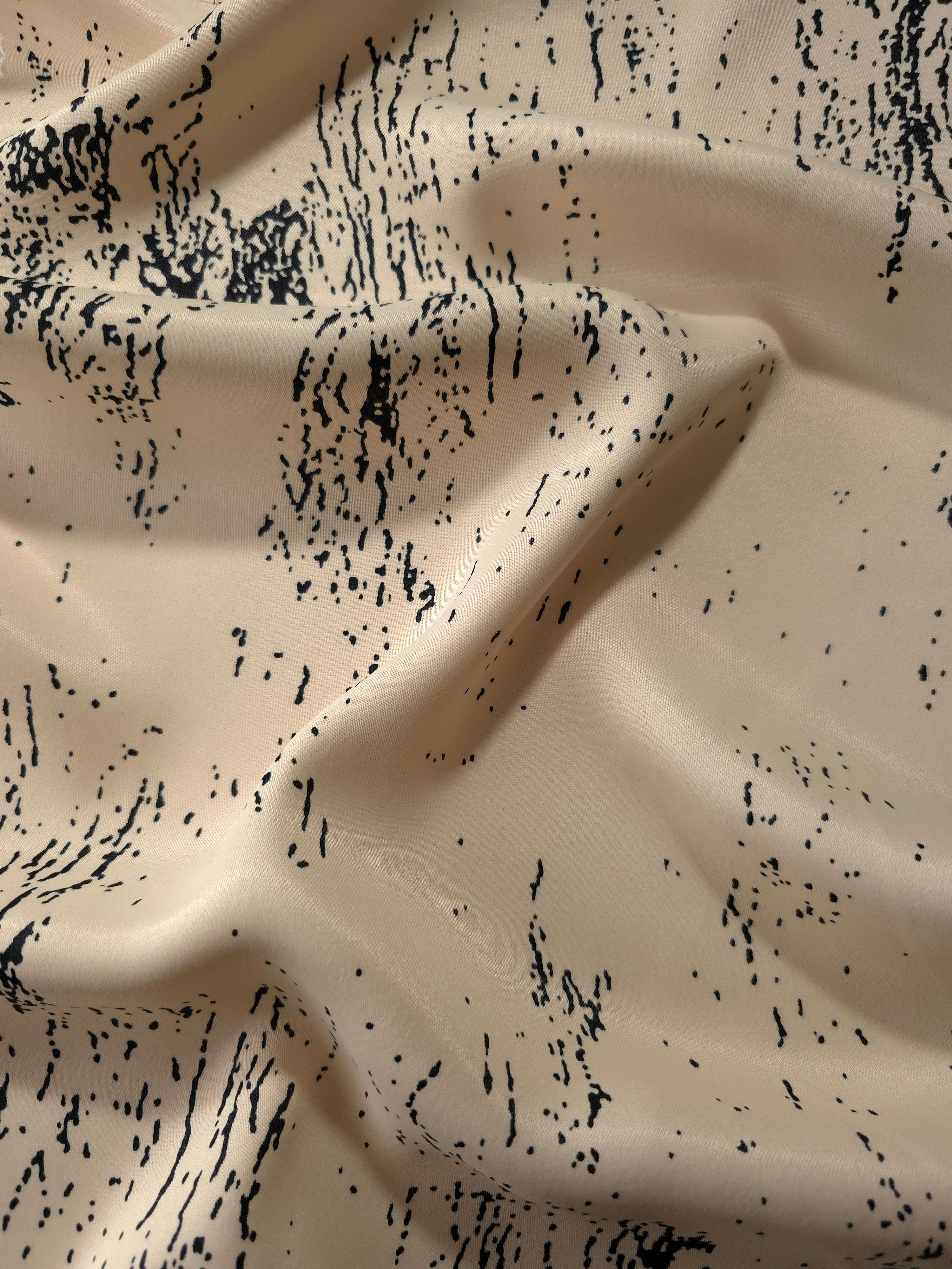 Wave shot of Vanilla Cream - Black silky rayon with distressed ink line print for soft abaya designs.
