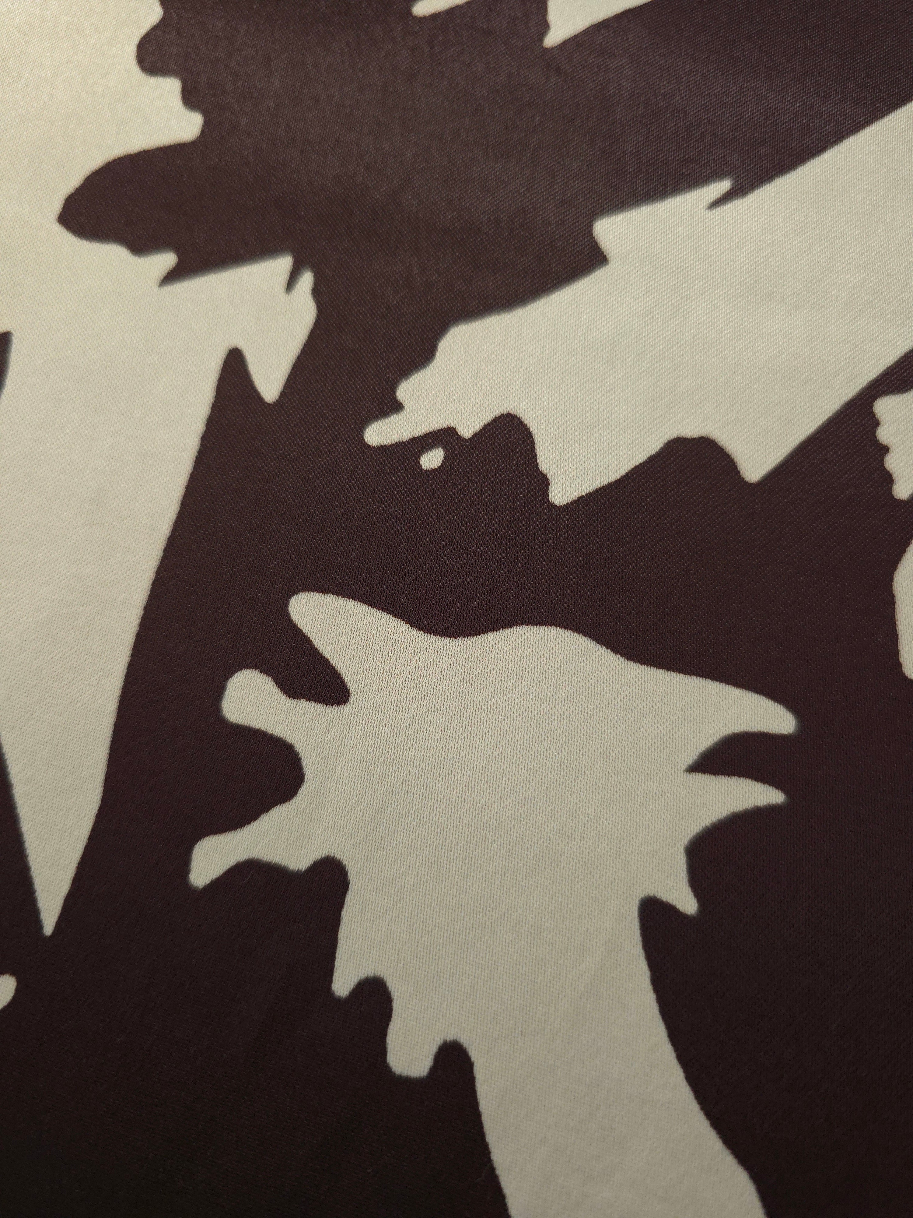 Close-up of Chocolate Brown - Black silky rayon fabric with bold abstract petal print and smooth finish.