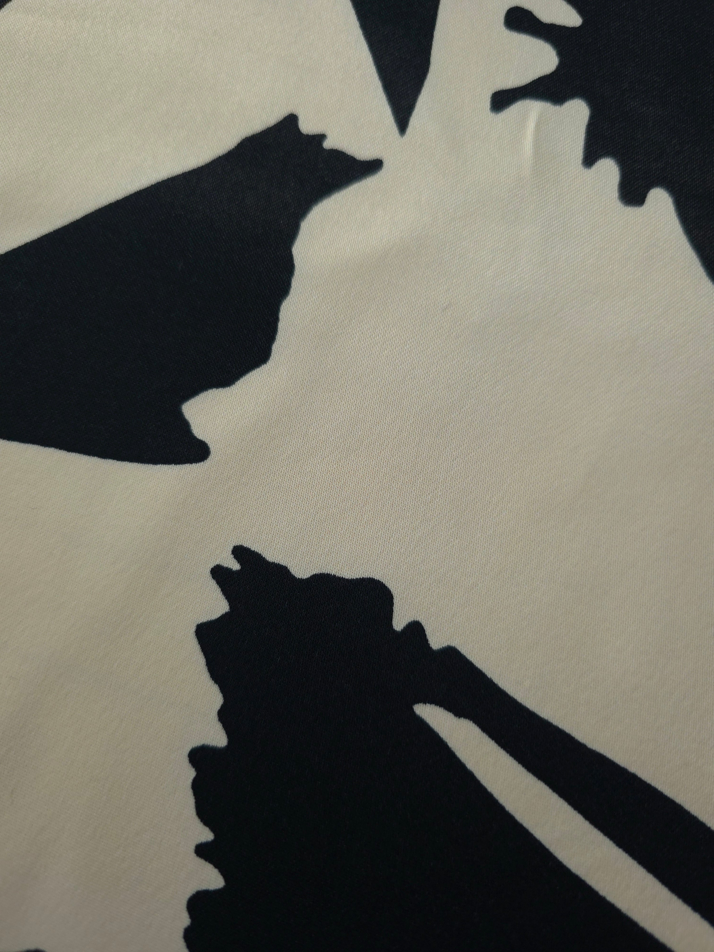 Close-up of Vanilla Cream - Black Turkish silky rayon fabric with bold abstract petal print and smooth surface.