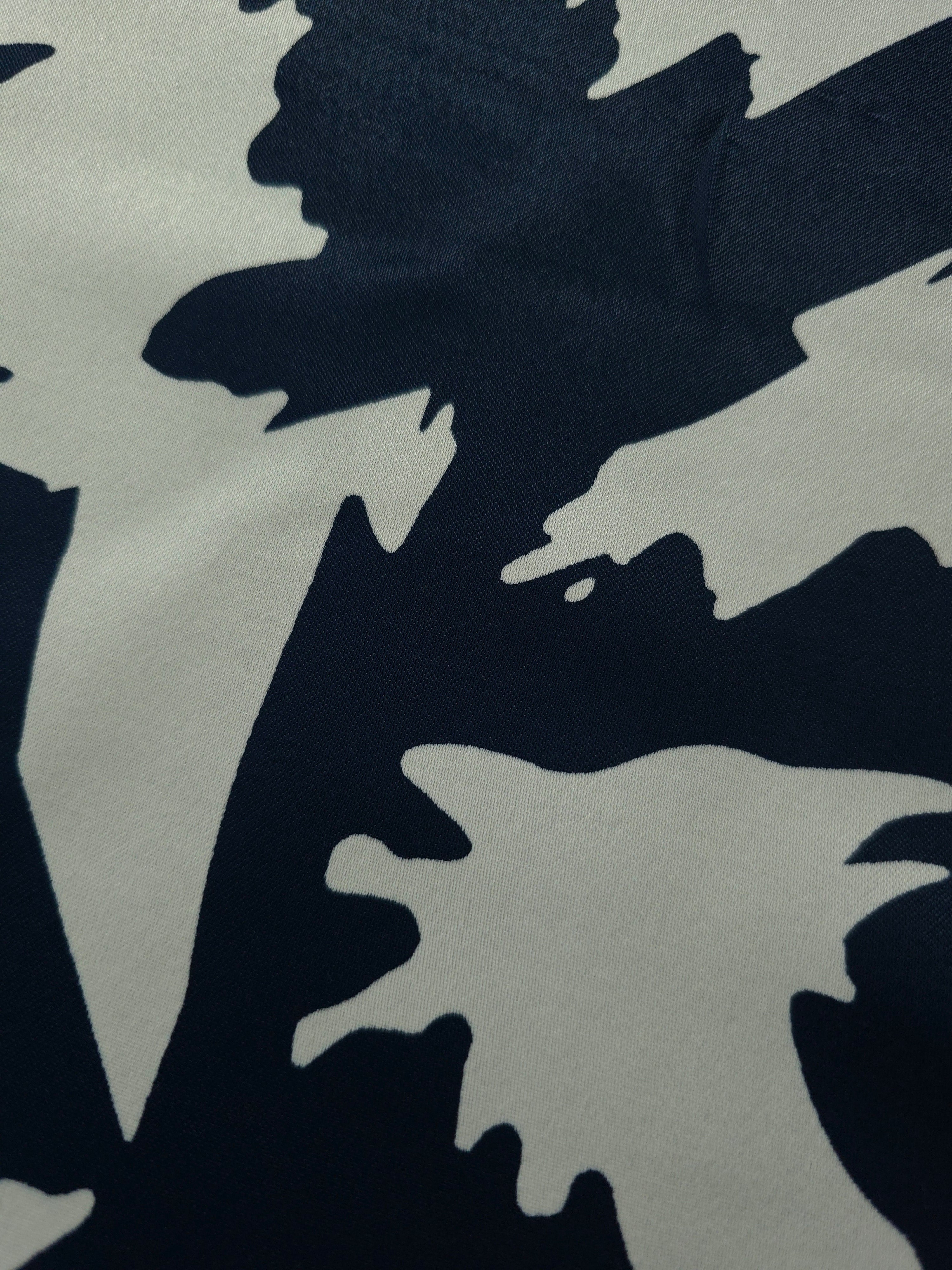Close-up of Midnight Blue - Black Turkish silky rayon fabric with bold abstract petal print for abaya and kaftan designs.