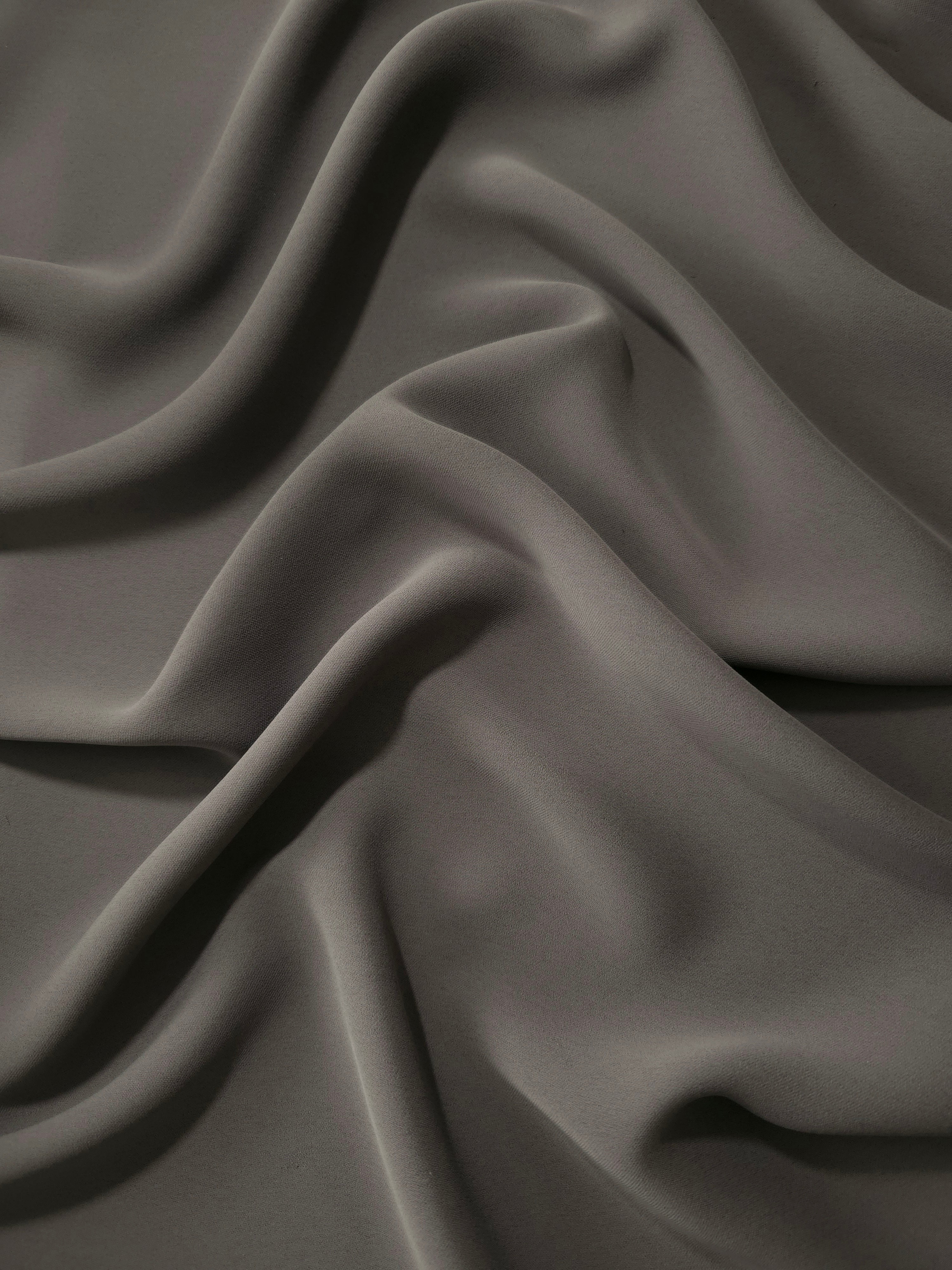 Draped Warm Charcoal Gray Korean polyester crepe showing opaque fluid folds for evening dresses and occasionwear
