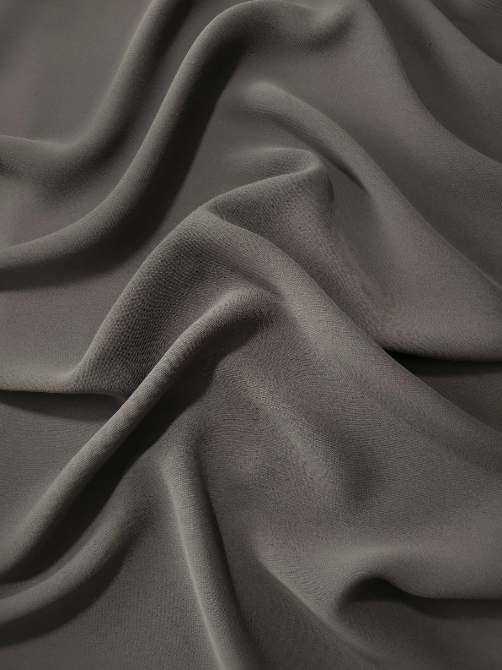 Draped Warm Charcoal Gray Korean polyester crepe showing opaque fluid folds for evening dresses and occasionwear