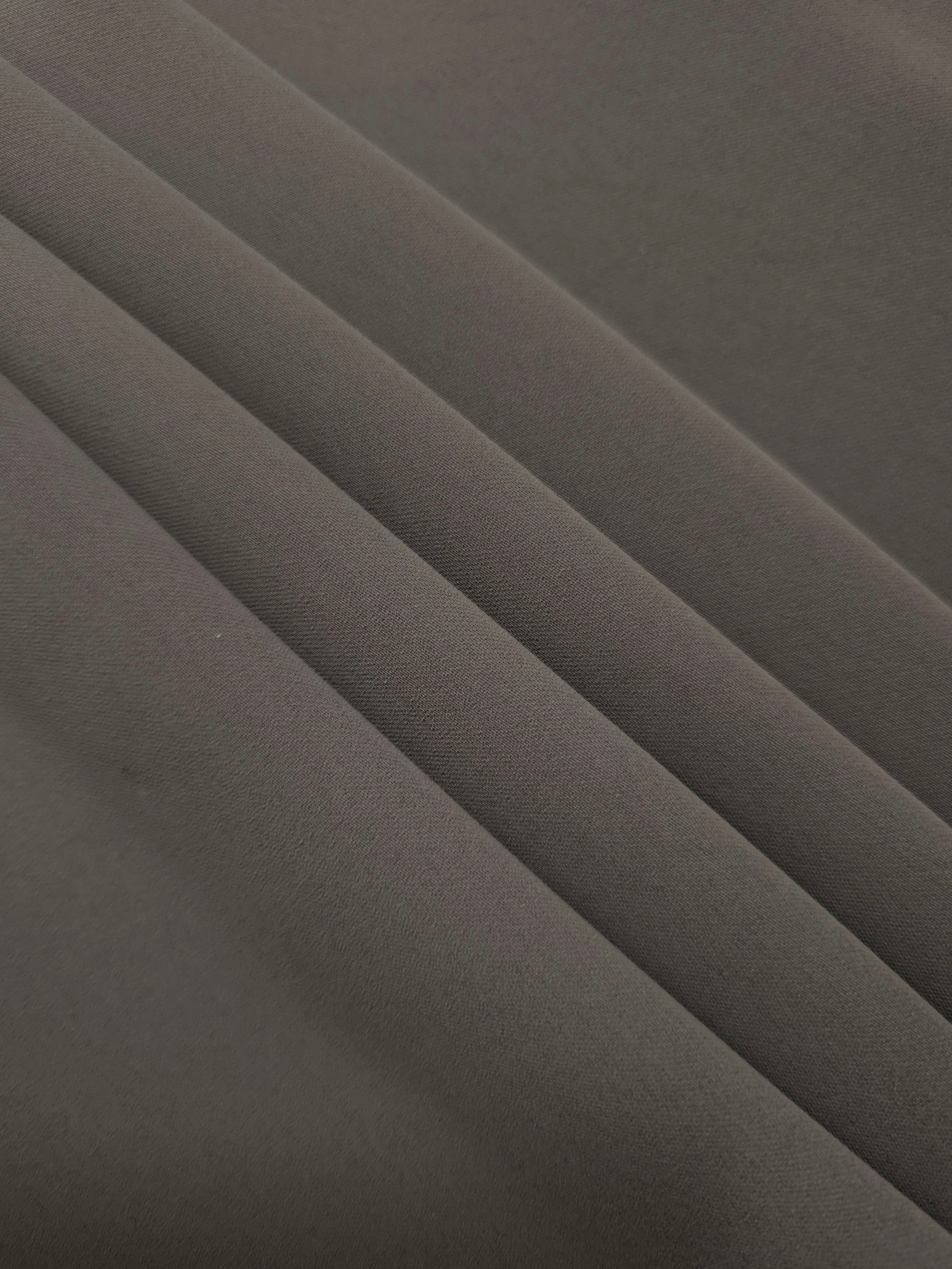 Layered Warm Charcoal Gray mechanical polyester crepe showing soft structure and slight mechanical stretch for tailoring