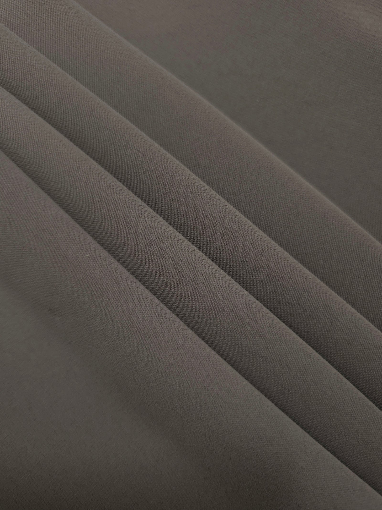 Layered Warm Charcoal Gray mechanical polyester crepe showing soft structure and slight mechanical stretch for tailoring