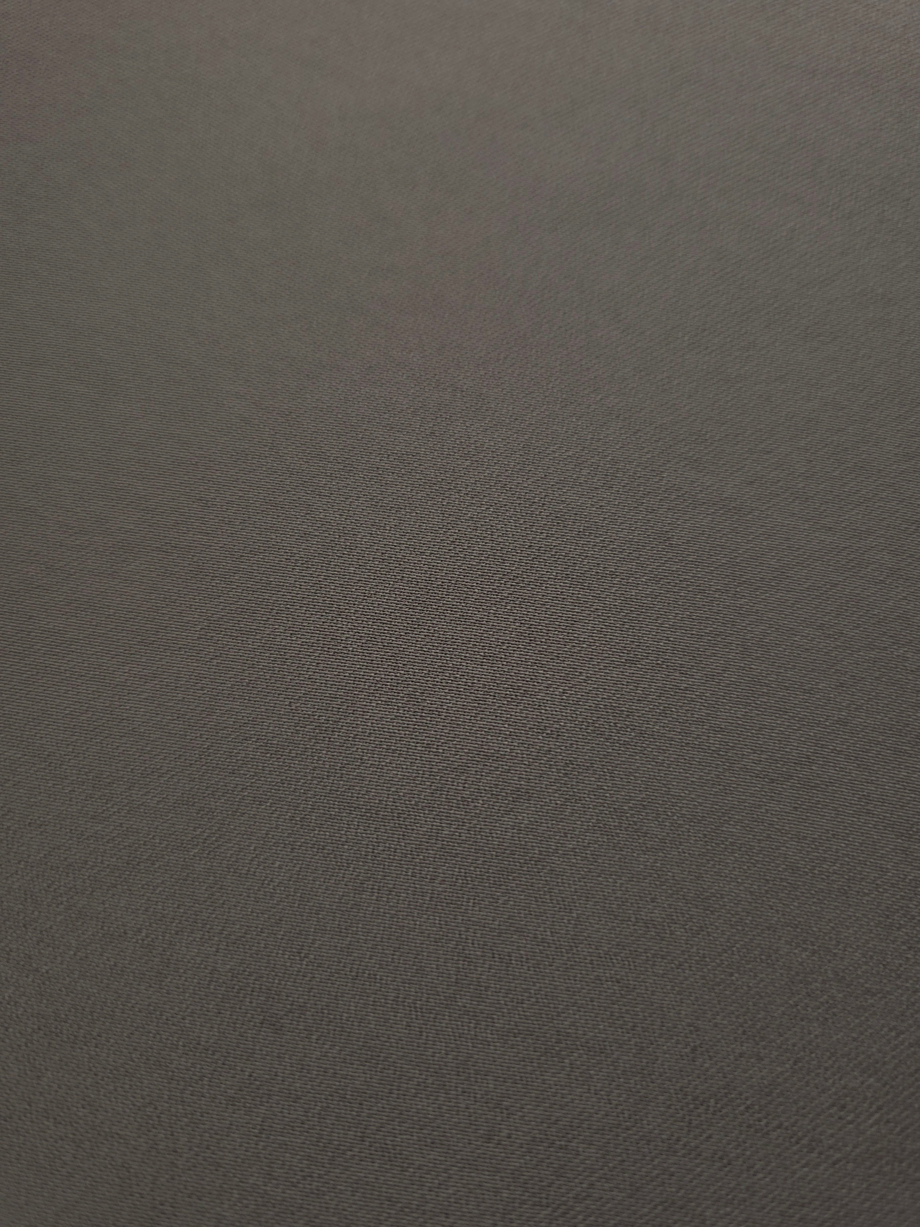 Close-up of Warm Charcoal Gray 100% mechanical polyester crepe showing fine woven texture and a silky-soft hand feel