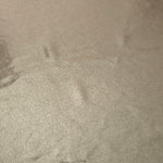 Close-up of Warm Greige Beige metallic foiled spandex showing reflective surface texture and the detailed shimmer finish
