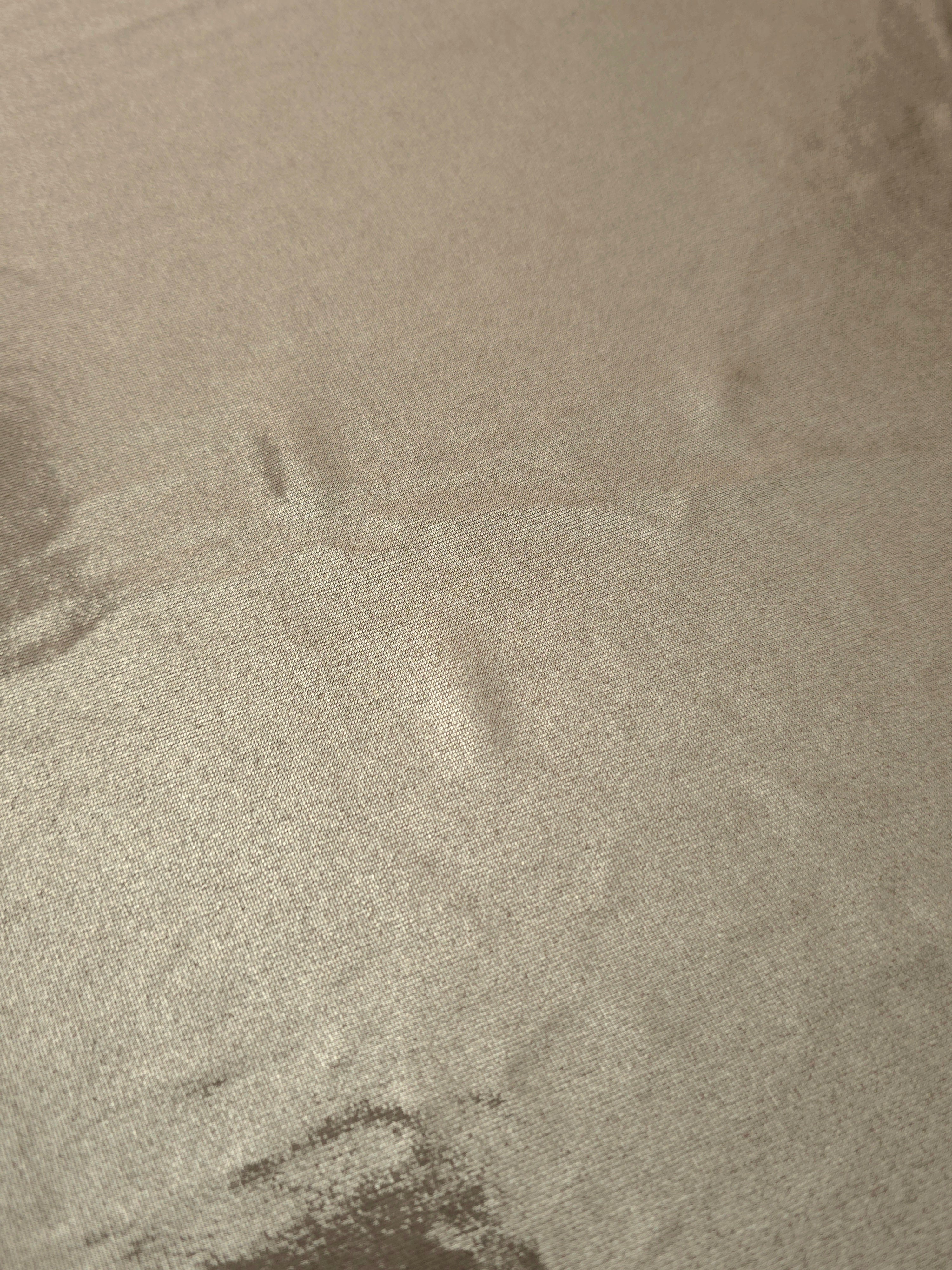 Close-up of Warm Greige Beige metallic foiled spandex showing reflective surface texture and the detailed shimmer finish