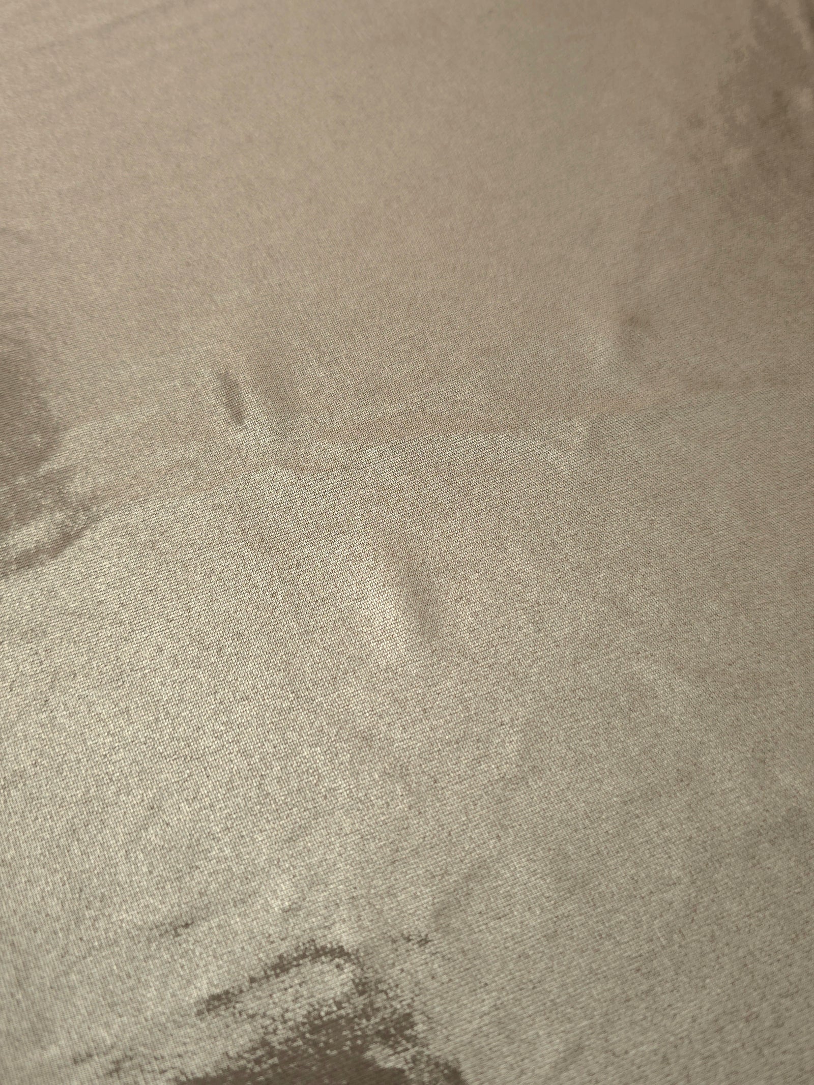 Close-up of Warm Greige Beige metallic foiled spandex showing reflective surface texture and the detailed shimmer finish