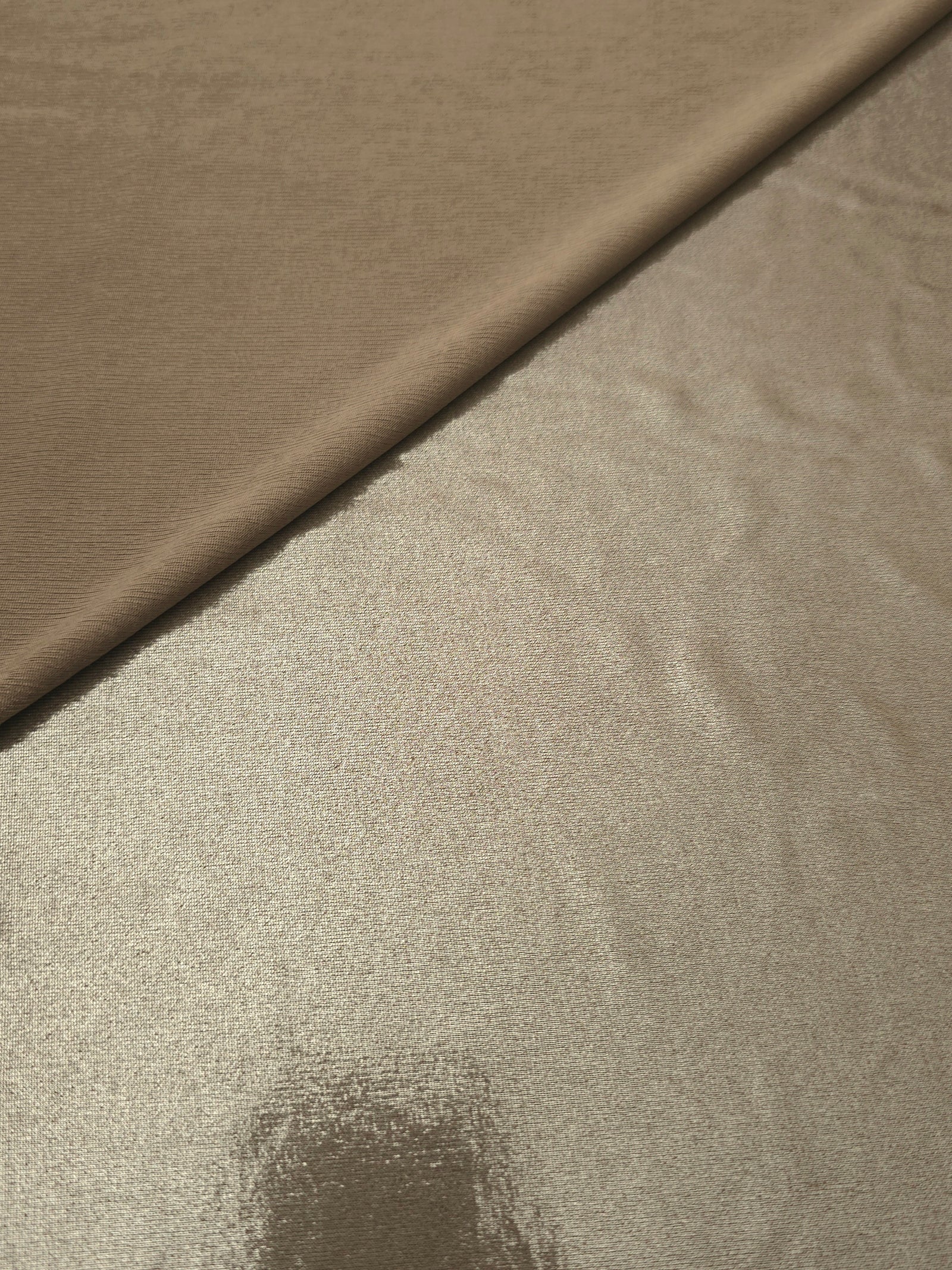 Warm Greige Beige shimmer spandex in a soft fold, showing metallic foil sheen and flexible drape for tops, skirts and costumes