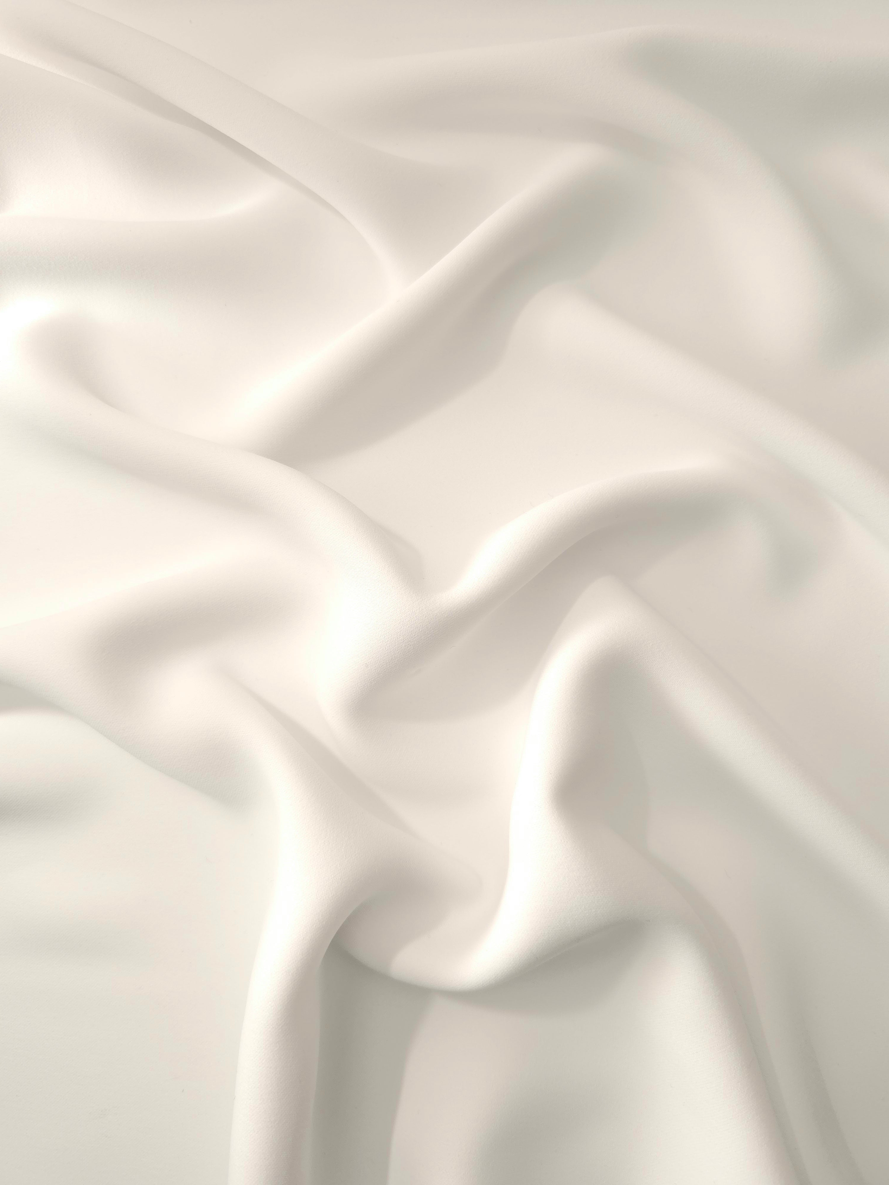 Draped Warm Ivory polyester crepe showing fluid folds for occasionwear, dresses and elegant apparel