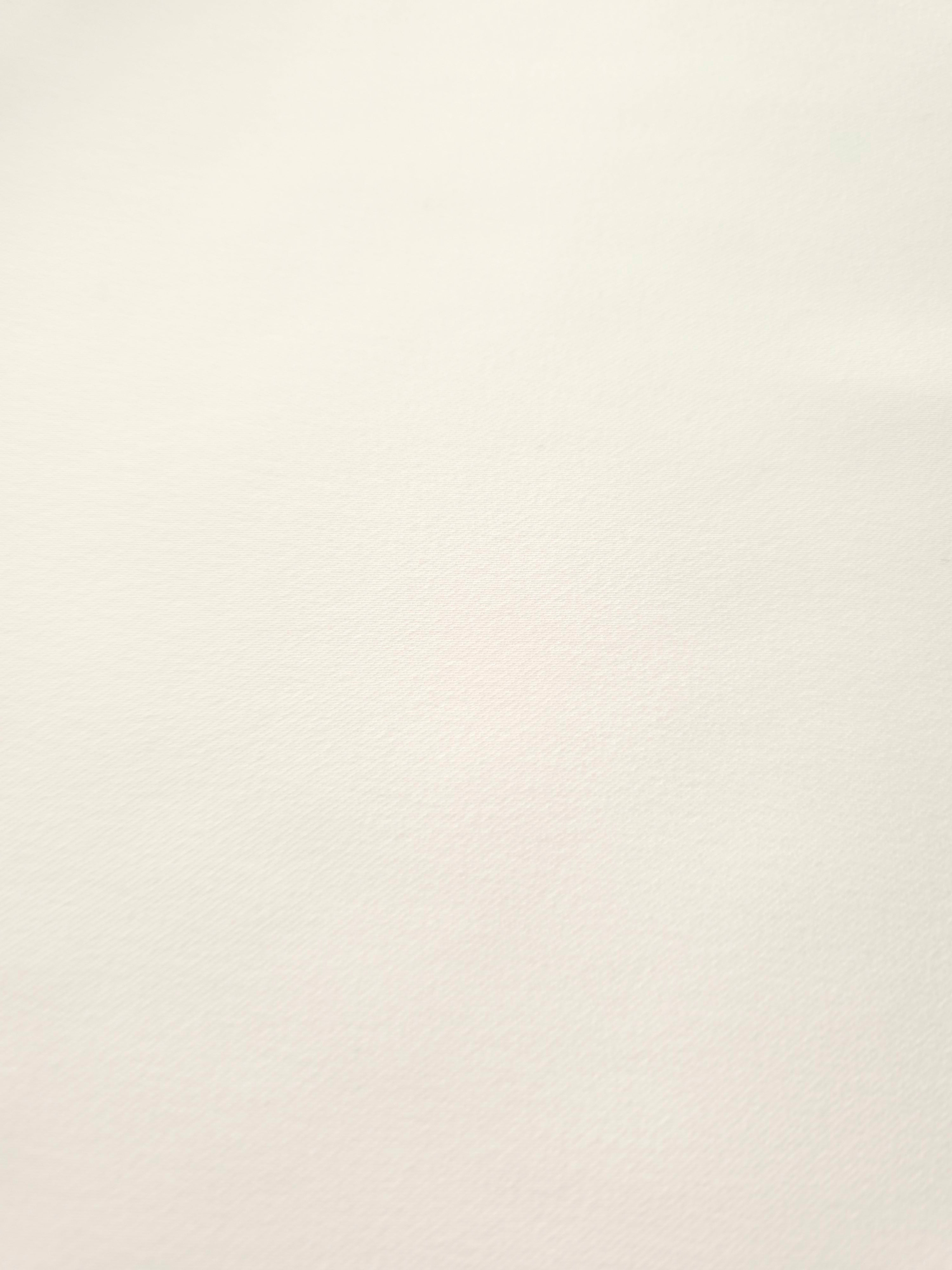 Close-up of Warm Ivory mechanical polyester crepe showing fine texture and a smooth silky-soft hand