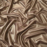 Warm Mushroom Taupe metallic stretch fabric arranged in elegant folds, showing reflective movement for occasionwear, costumes and fashion design