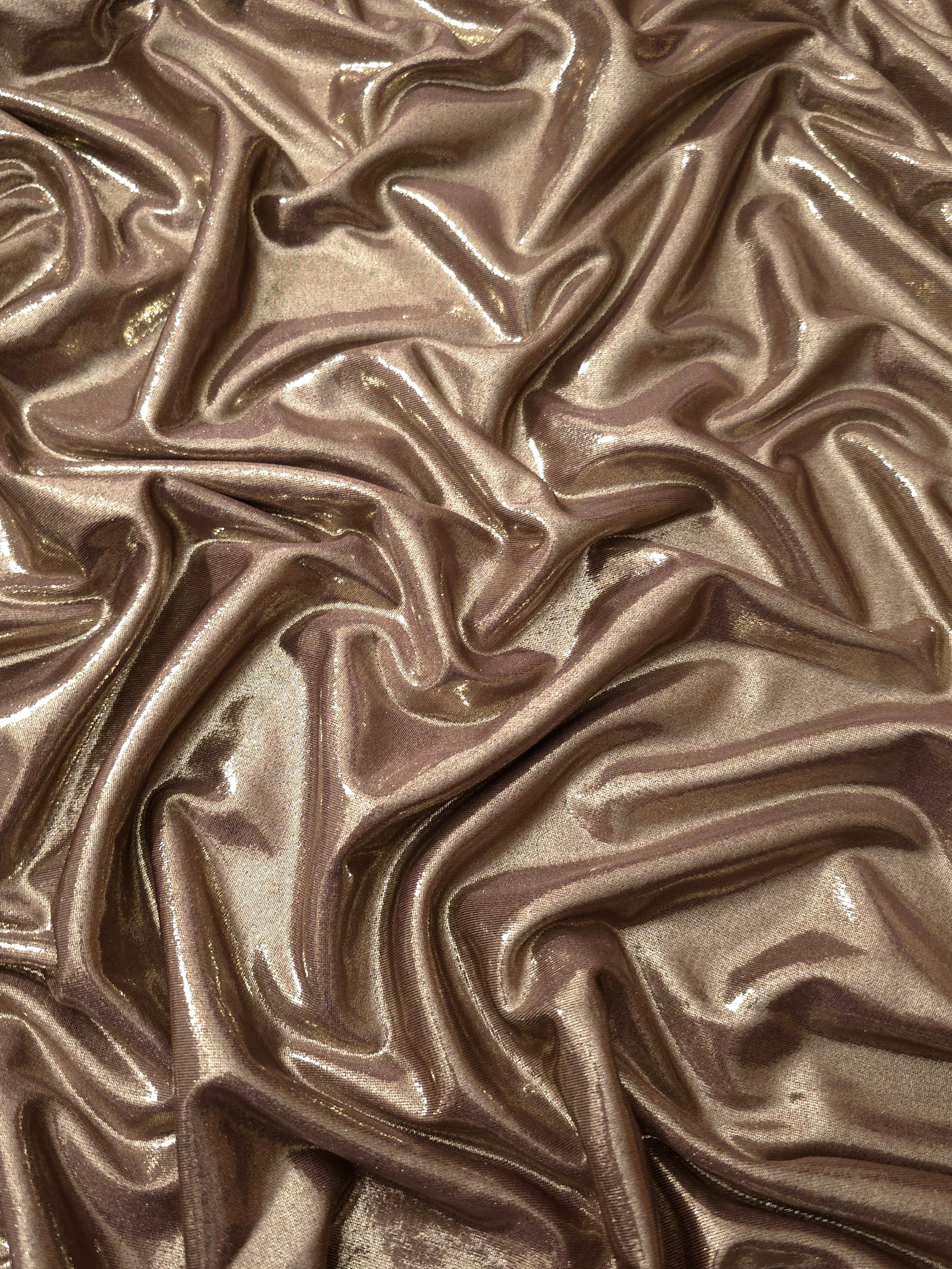 Warm Mushroom Taupe metallic stretch fabric arranged in elegant folds, showing reflective movement for occasionwear, costumes and fashion design