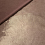 Warm Mushroom Taupe metallic stretch fabric in a soft fold, revealing reflective drape for dancewear, dresses and statement apparel