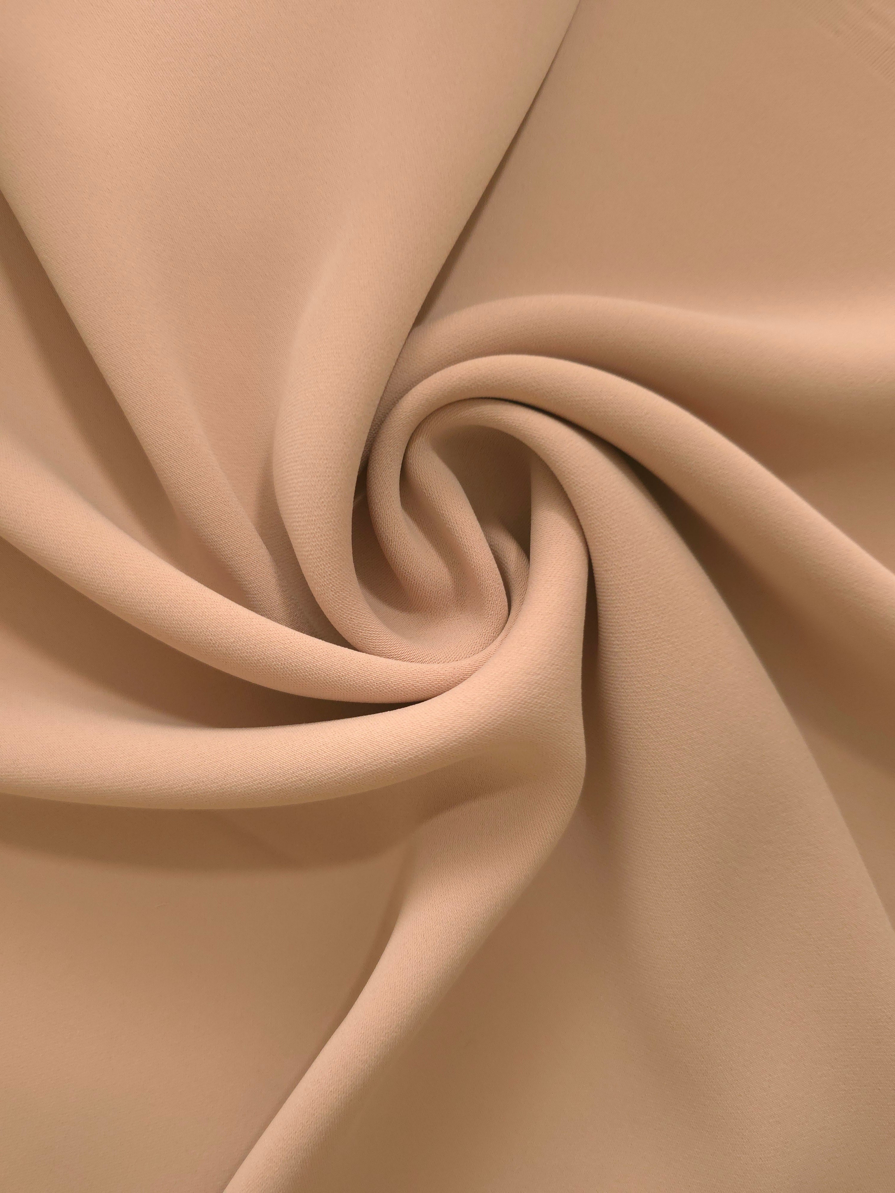 Circular drape of Warm Sand Beige polyester crepe showing flowing movement for occasion dresses and modest fashion