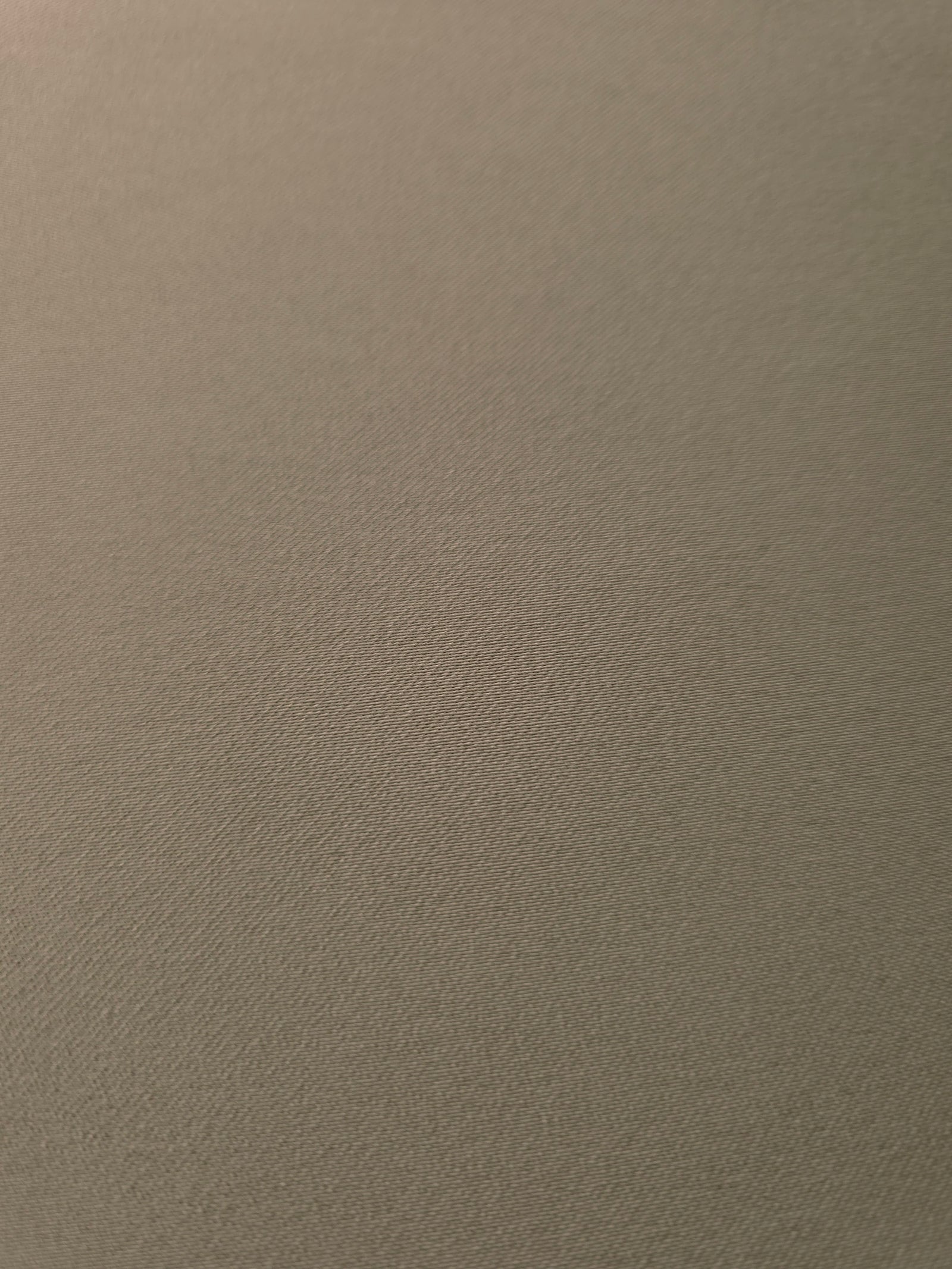 Texture detail of Warm Stone Taupe mechanical polyester crepe, a smooth woven fabric with a soft silky hand