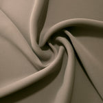 Warm Stone Taupe opaque polyester crepe in a spiral drape, showing flowing form for skirts and modest garments