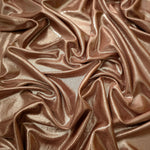 Warm Taupe Beige shimmer stretch fabric in draped folds, highlighting metallic foil sheen for evening dresses, costumes and statement apparel