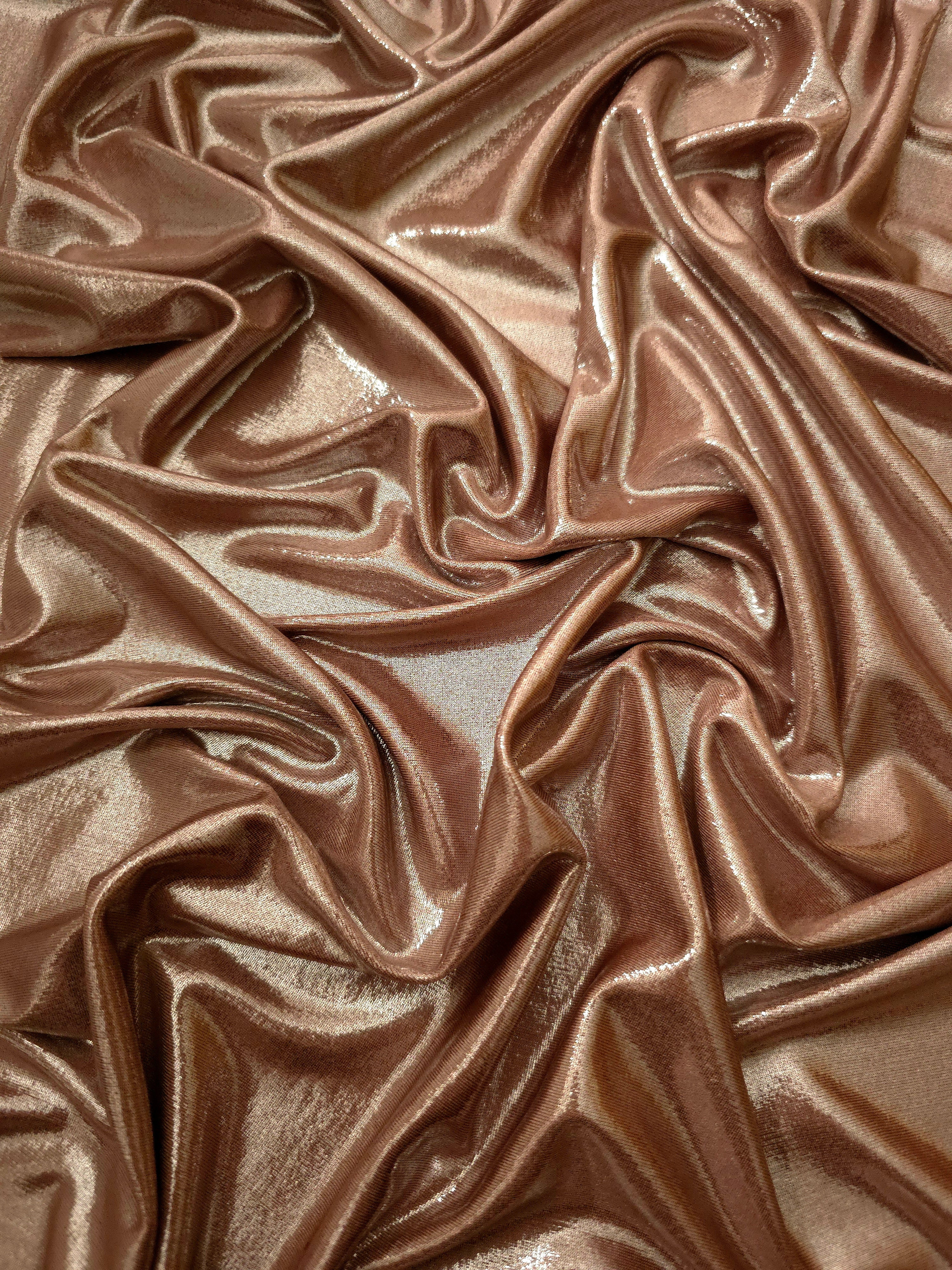 Warm Taupe Beige shimmer stretch fabric in draped folds, highlighting metallic foil sheen for evening dresses, costumes and statement apparel