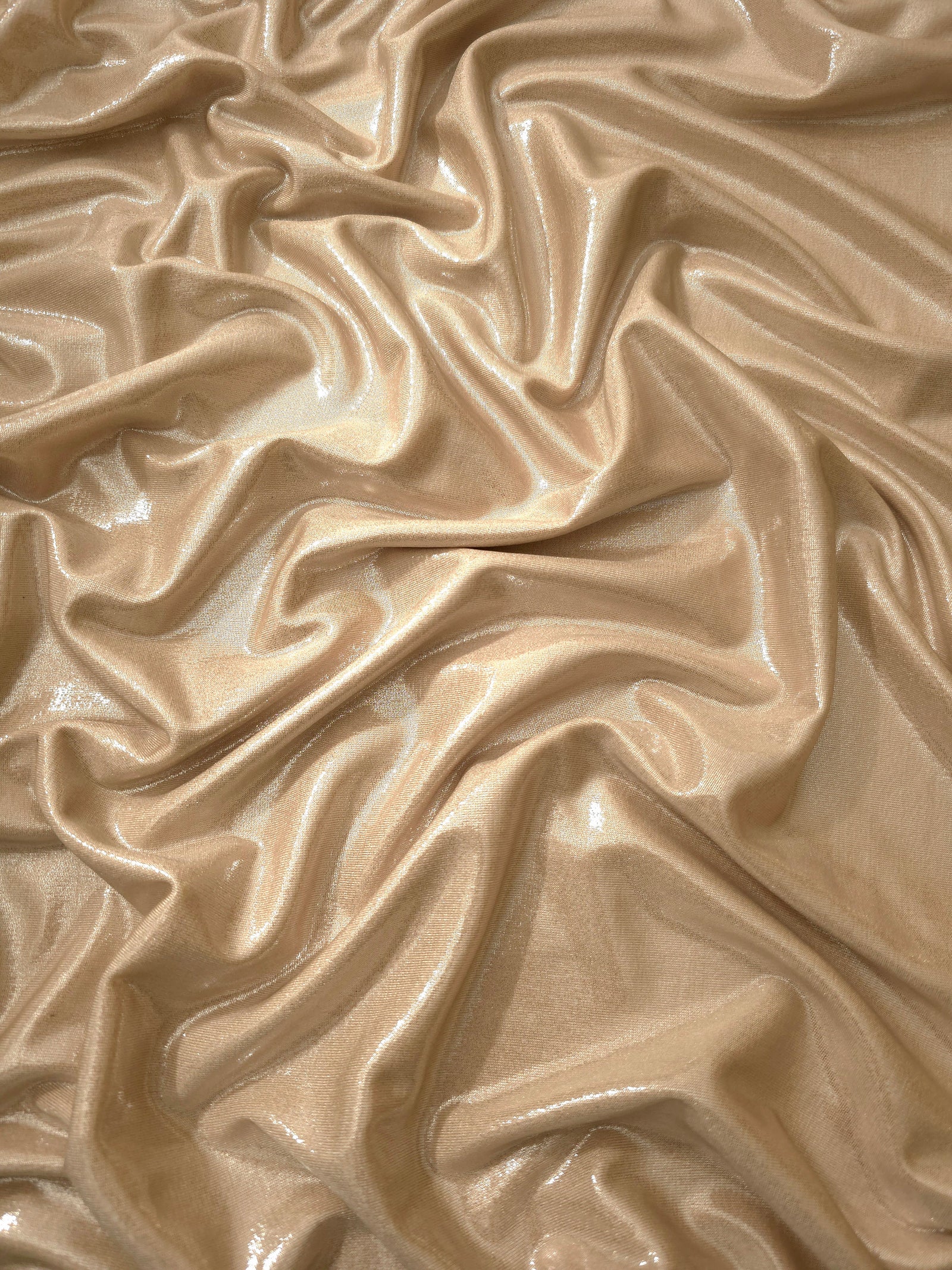 Draped Warm Taupe Beige metallic foiled spandex showing reflective folds and flexible flow for dresses, stagewear and occasion looks