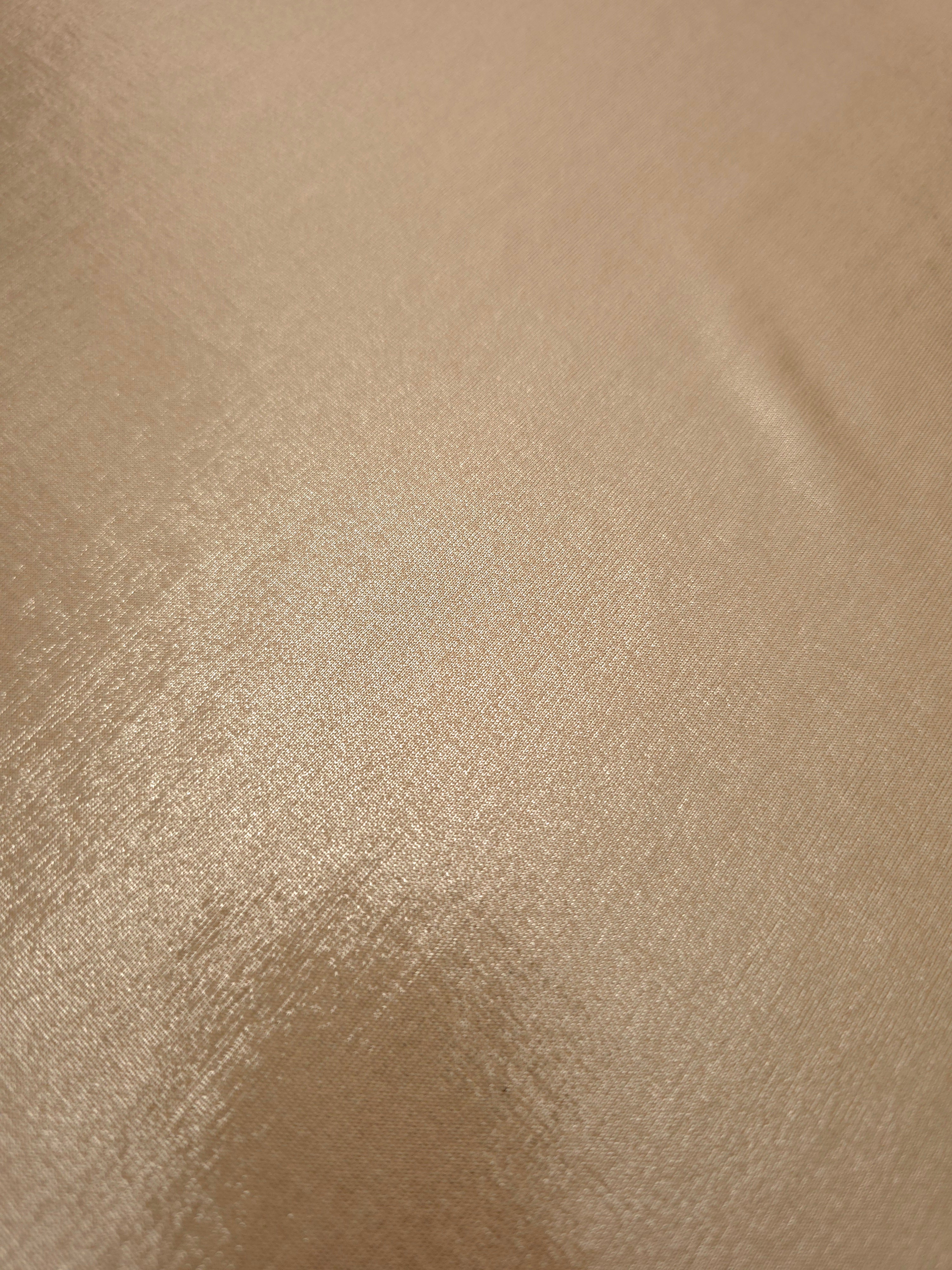 Close-up of Warm Taupe Beige metallic foiled spandex showing reflective surface texture and the detailed shimmer finish