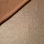 Soft fold of Warm Taupe Beige metallic foiled spandex highlighting reflective sheen and supple movement for dresses and stagewear
