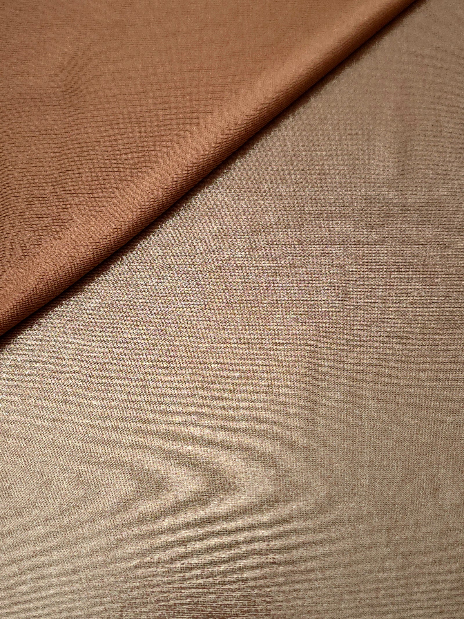 Soft fold of Warm Taupe Beige metallic foiled spandex highlighting reflective sheen and supple movement for dresses and stagewear