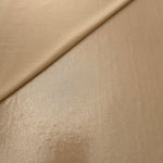 Warm Taupe Beige shimmer spandex in a soft fold, showing metallic foil sheen and flexible drape for tops, skirts and costumes