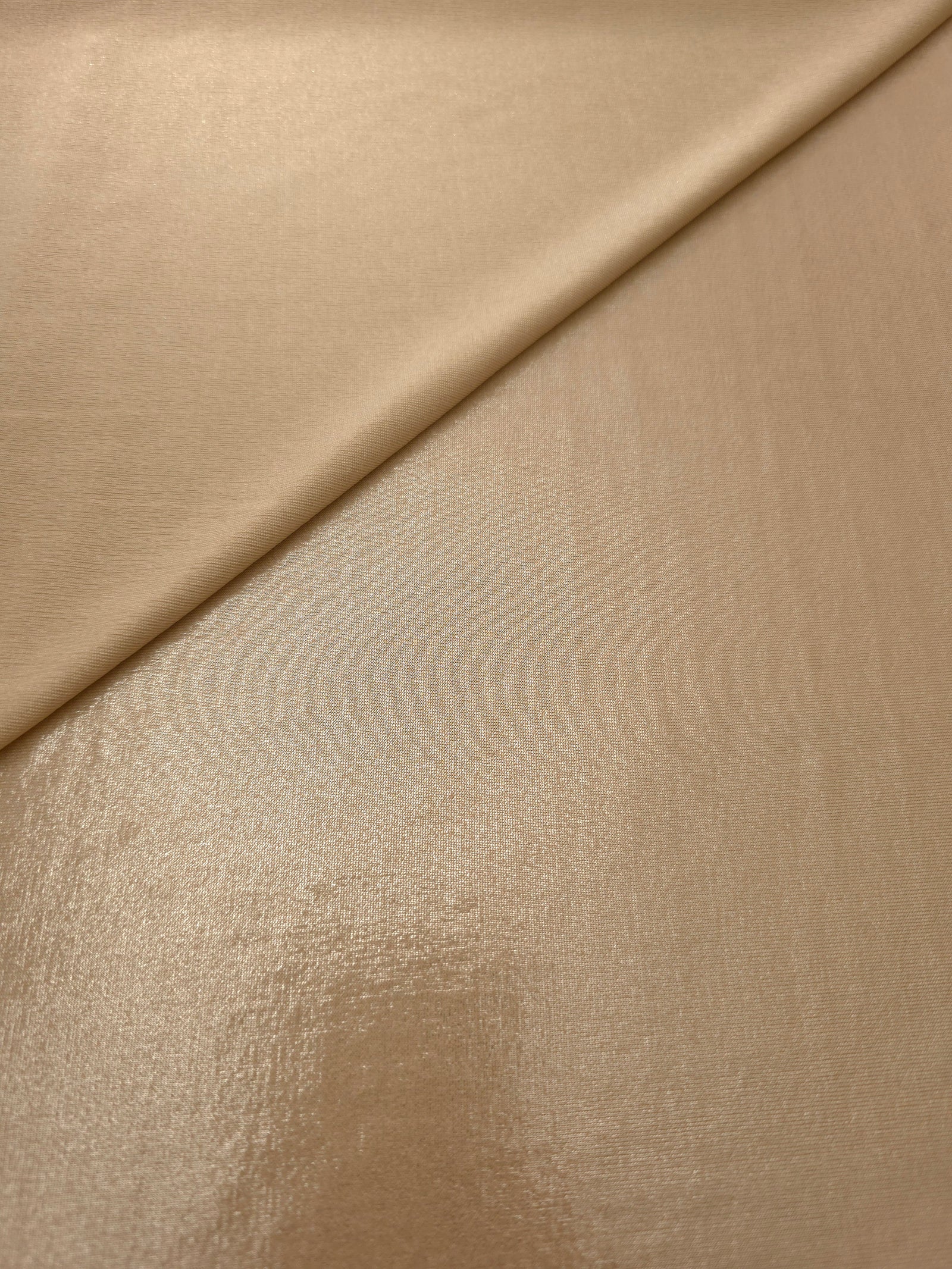 Warm Taupe Beige shimmer spandex in a soft fold, showing metallic foil sheen and flexible drape for tops, skirts and costumes